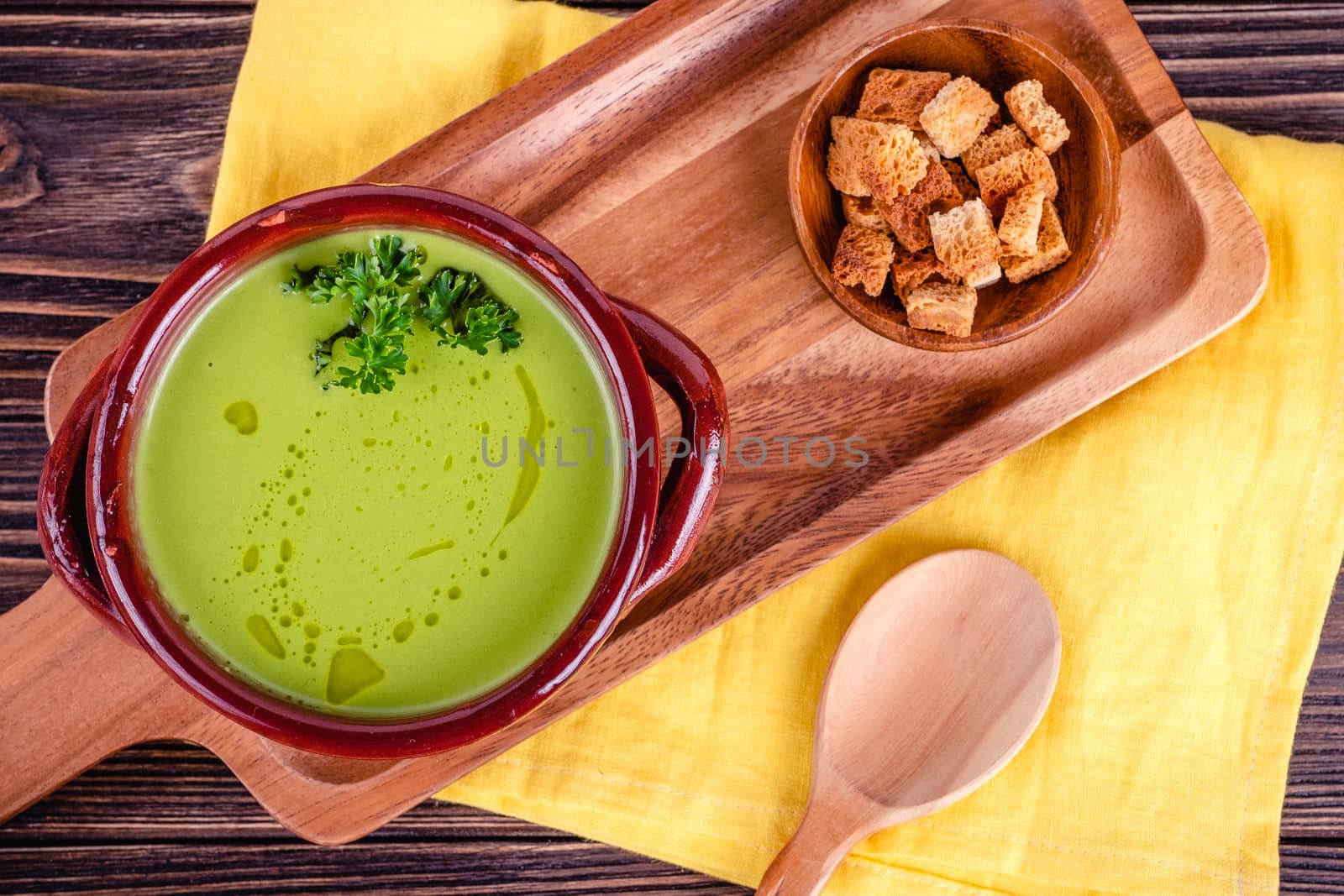 Fresh asparagus creamy soup and ingredients on a wooden table. by Fischeron