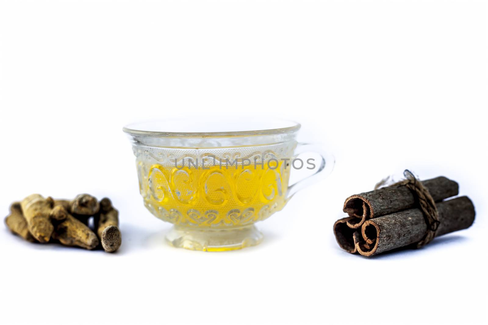 Popular turmeric tea isolated on white with its entire ingredients which are turmeric powder and raw, honey and cinnamon sticks.Used for detoxifying body.Isolated on white. by mirzamlk
