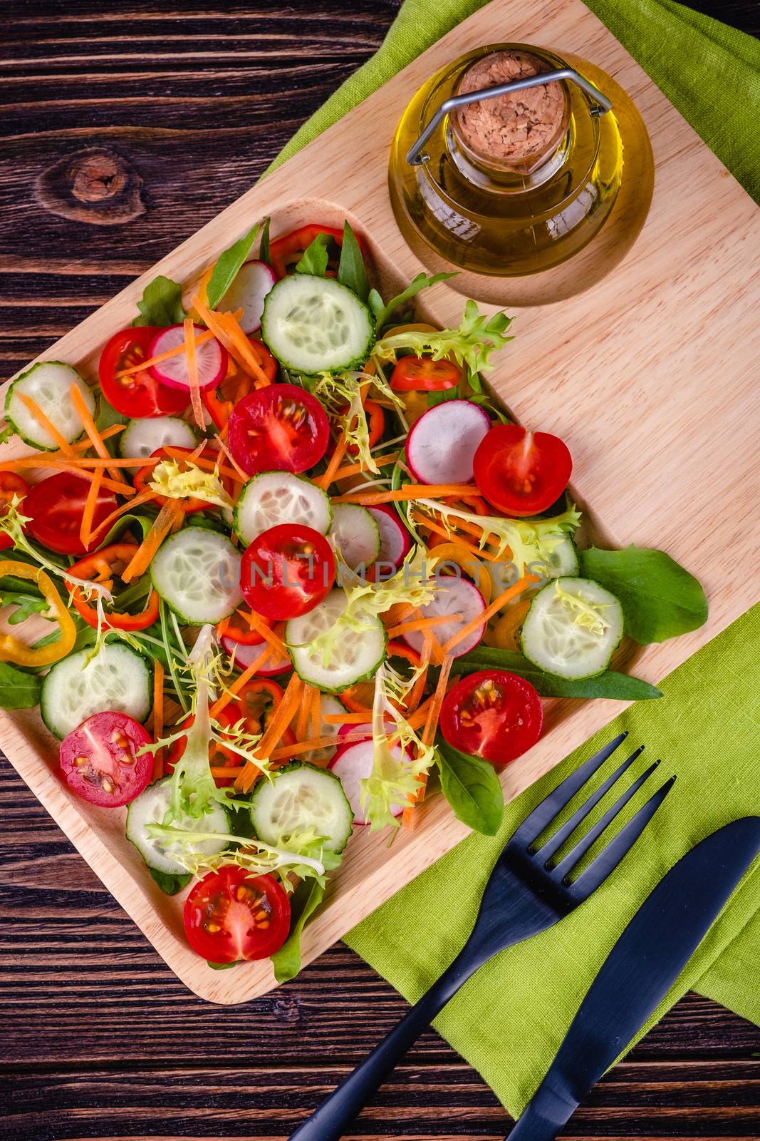 Fresh chopped vegetables on a plate on a wooden table on a rustic wooden background, selective focus