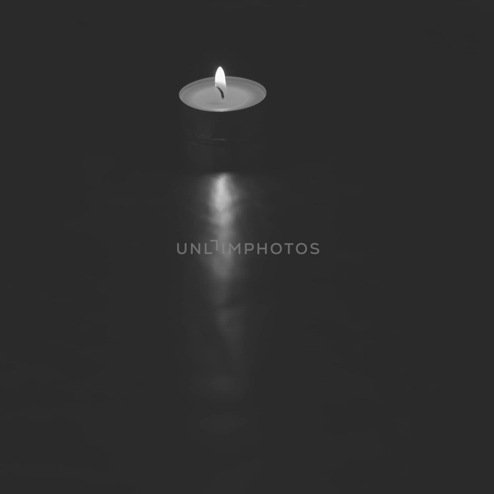 Small lit candle on dark and silver background by raul_ruiz