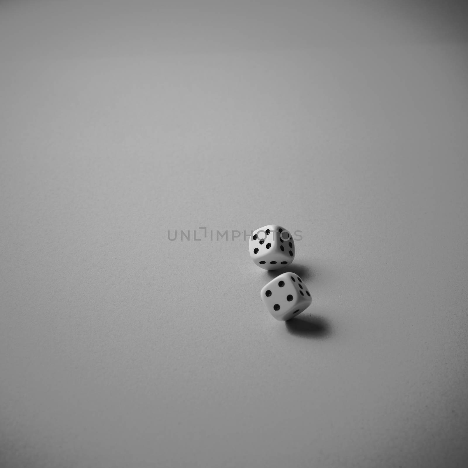 Two dice rolling on white background, black and white, minimalism