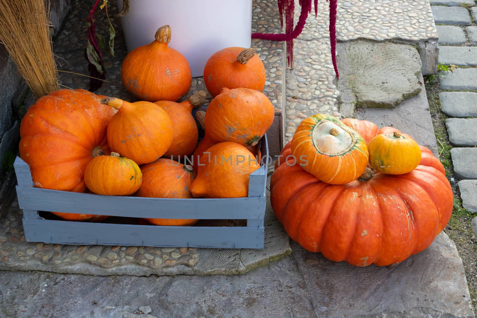 Orange pumpkins of various sizes lie on the porch of the house.The Concept Of Halloween.