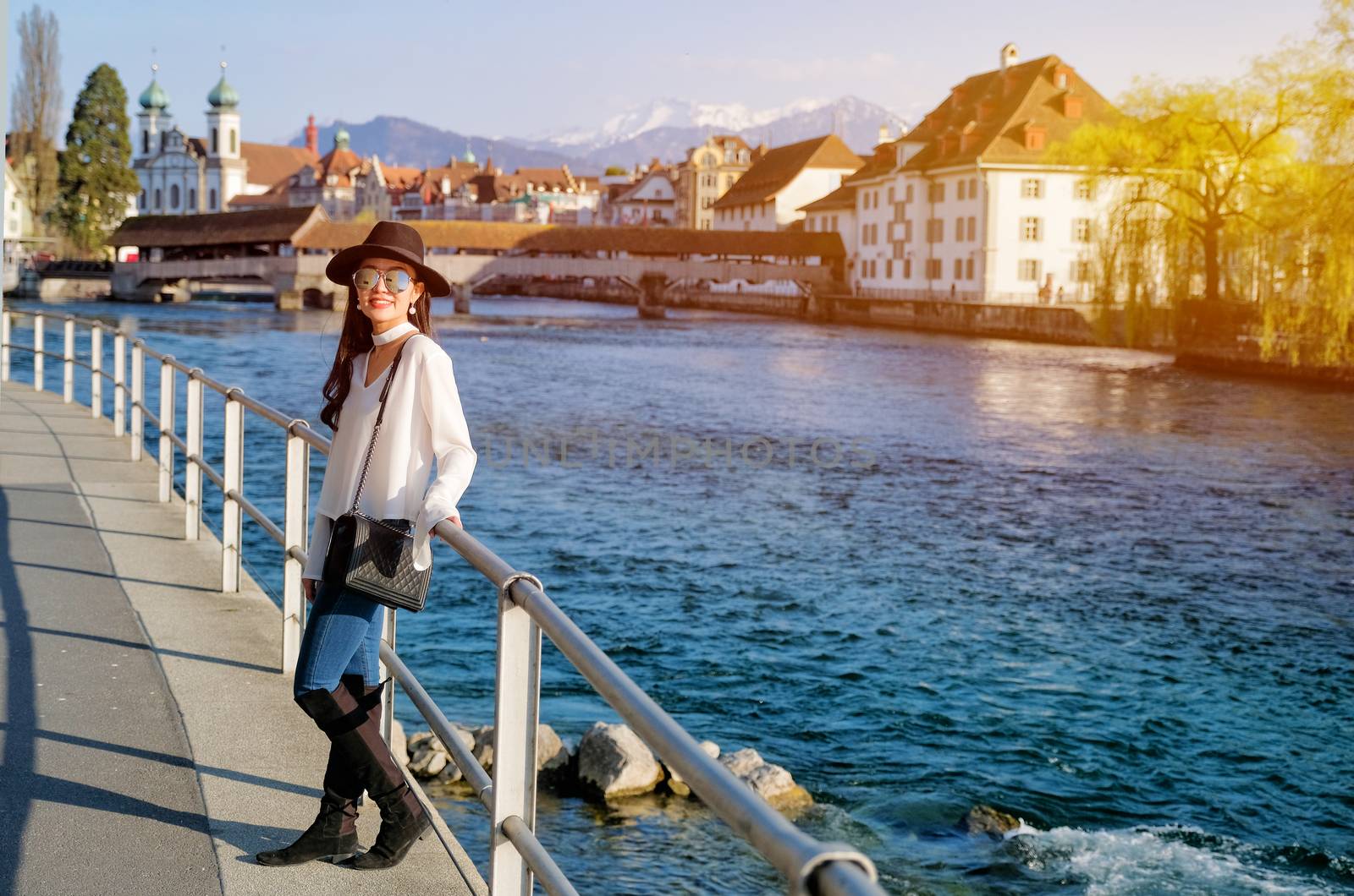 Young female traveler in front of the famous wooden bridge in Lucerne city in Switzerland