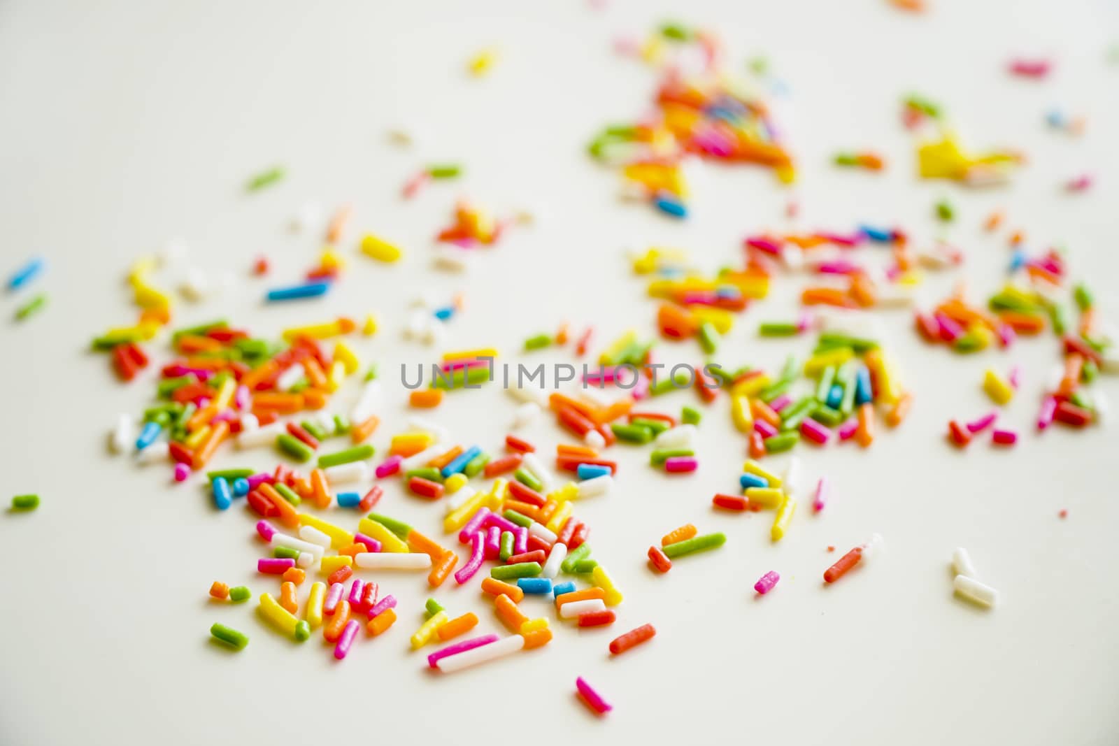 Selective focus colorful sugar sprinkle dots for decoration topping cake and ice cream on the table. by chiawth