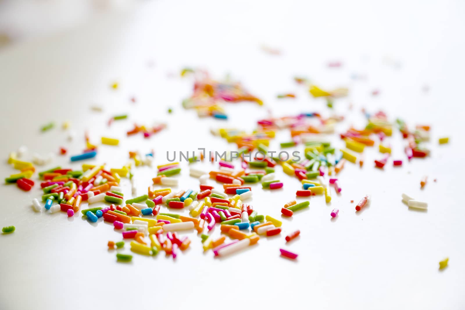 Selective focus colorful sugar sprinkle dots for decoration topping cake and ice cream on the table.