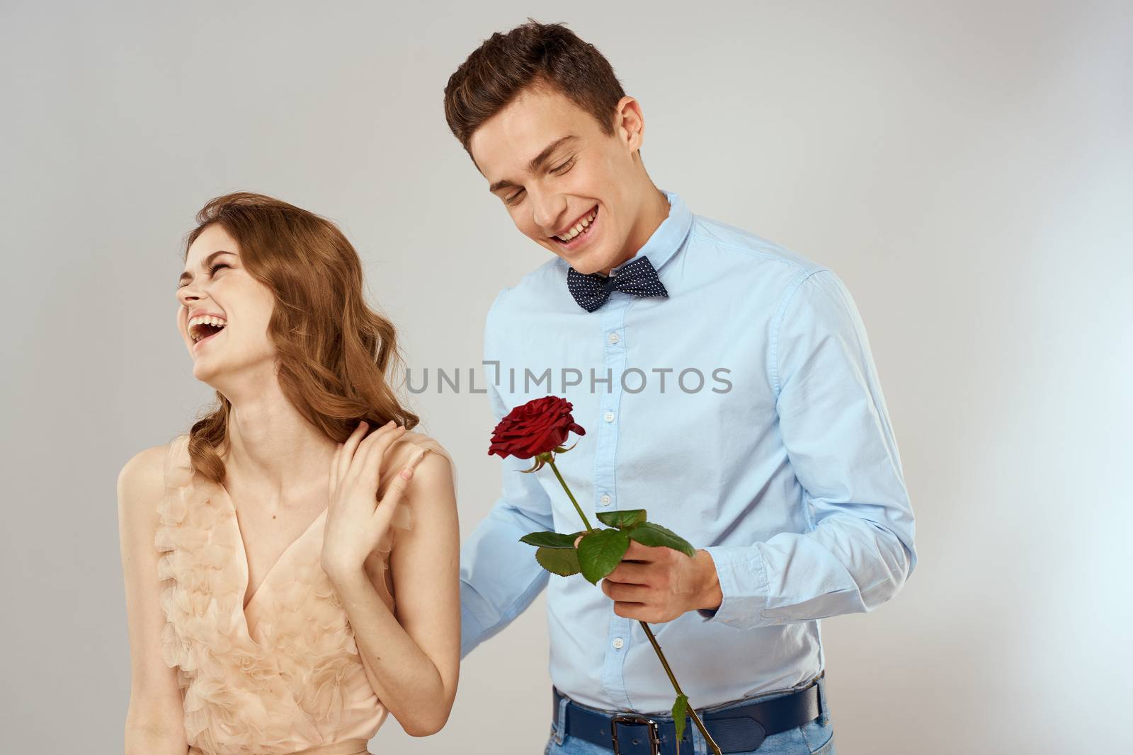 Cheerful young couple romance embrace relationship red rose lifestyle light background by SHOTPRIME