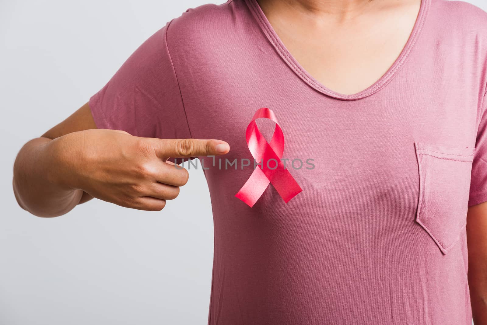 woman wear pink shirt pointing finger to pink breast cancer awar by Sorapop
