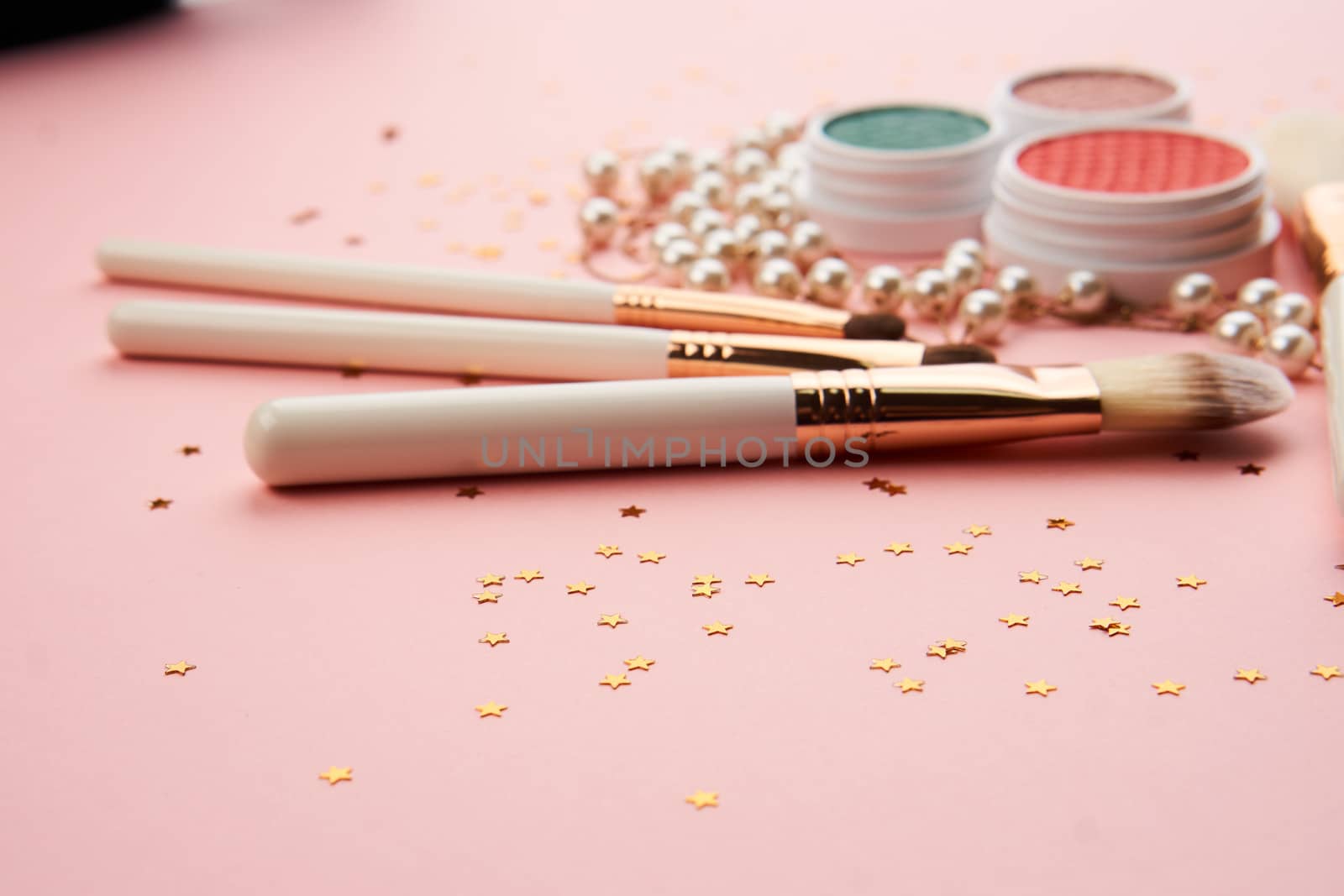 makeup brushes and eyeshadow professional cosmetics on pink background by SHOTPRIME