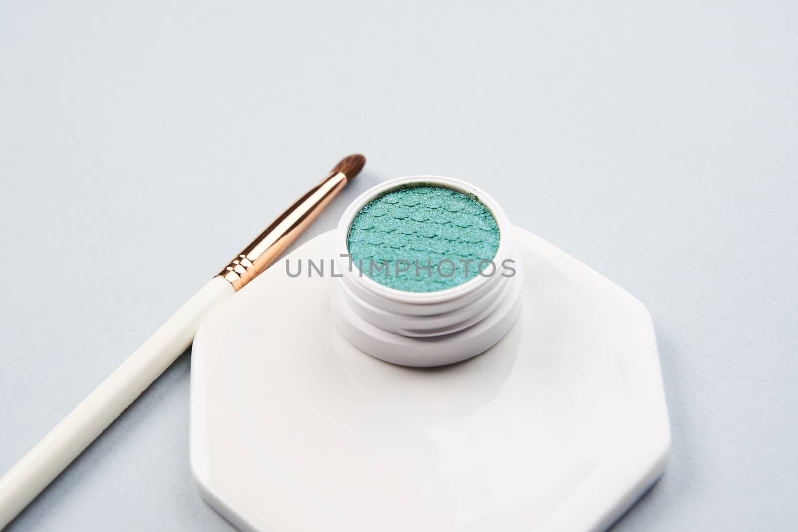 Green eyeshadow and makeup brush on white stand isolated background by SHOTPRIME