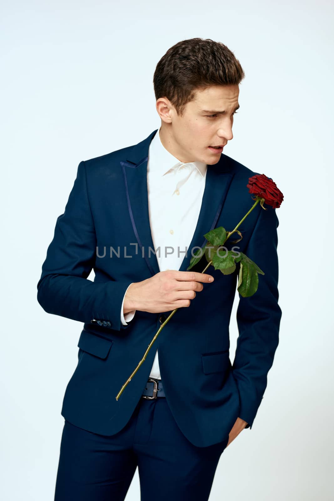 A man in a suit with a rose in his hands a gift date light background by SHOTPRIME