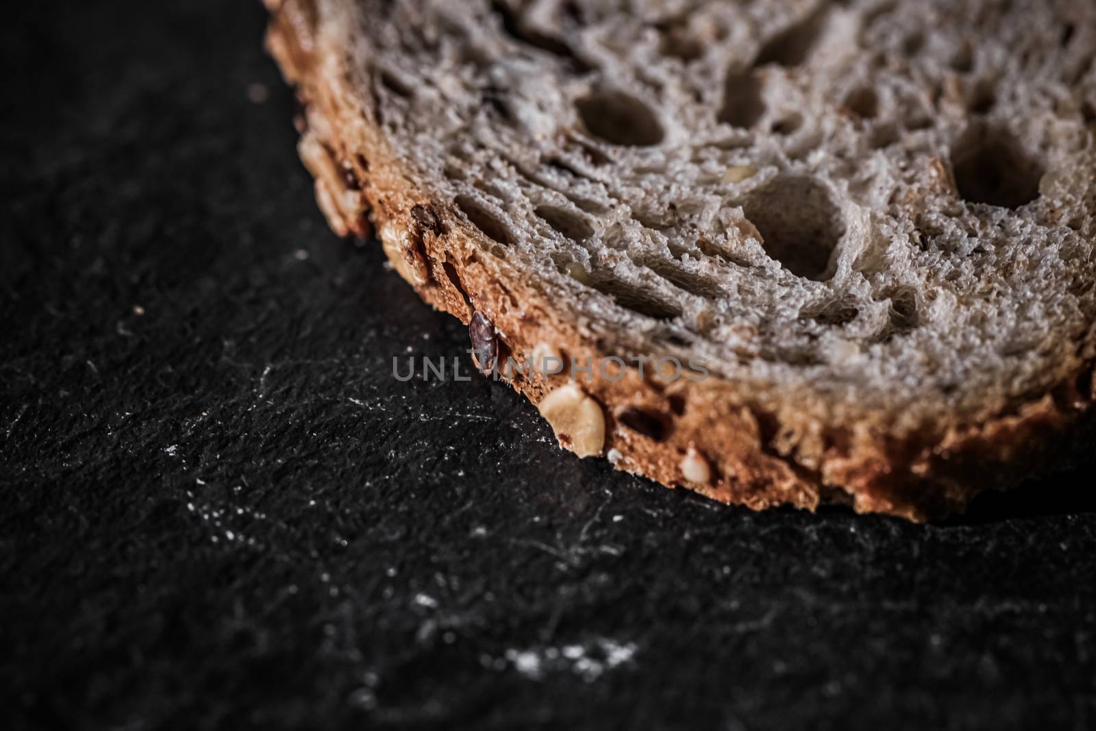 Fresh whole grain seeded bread, organic wheat flour, closeup slice texture as background for food blog or cook book recipe by Anneleven