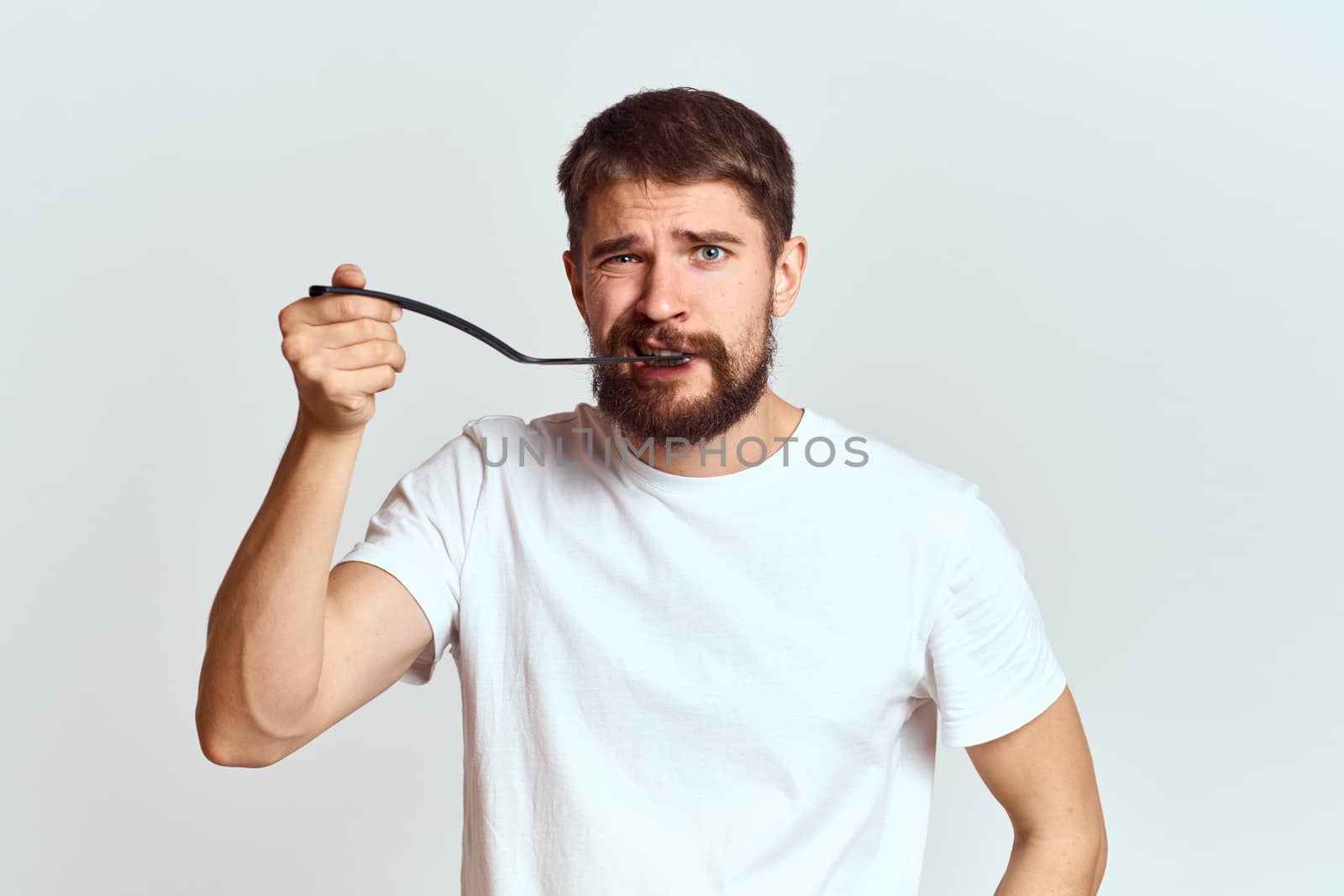 man with cooking shovel and white t-shirt close-up cropped view emotion gesturing with hand by SHOTPRIME