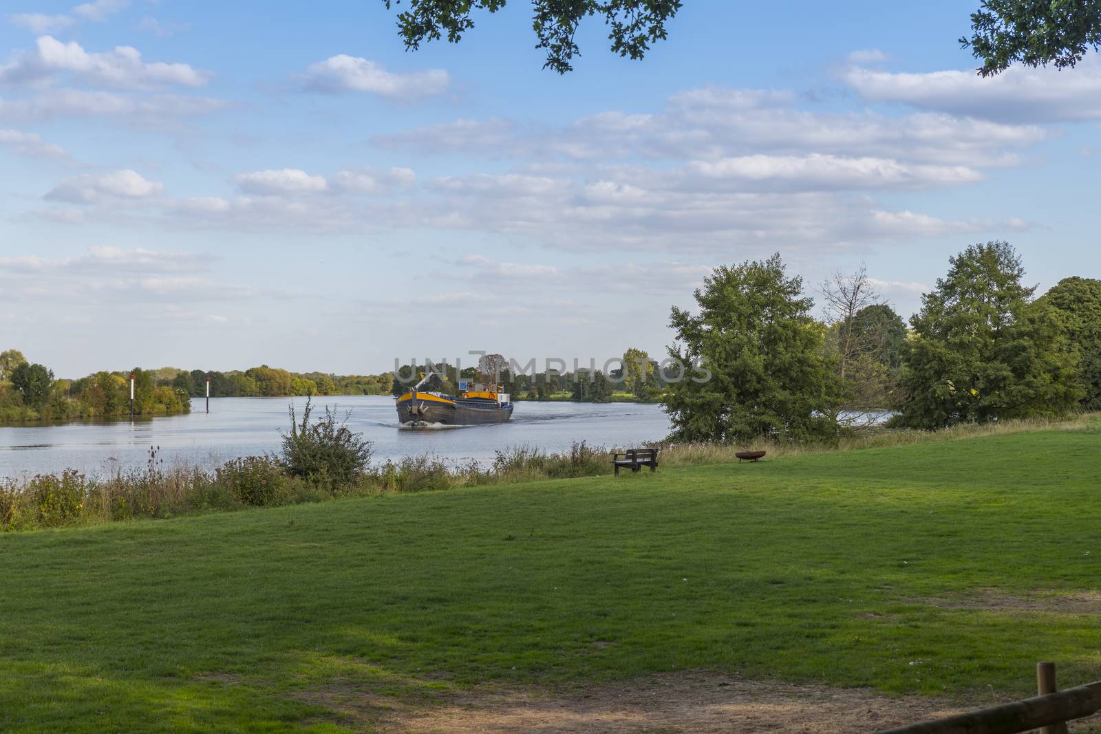 transport bij ship over the river maas in Holland with green and nature around