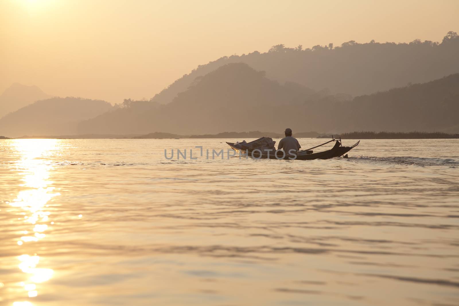 Nam Ou River, golden water at sunrise boats and landscape with mountains . High quality photo