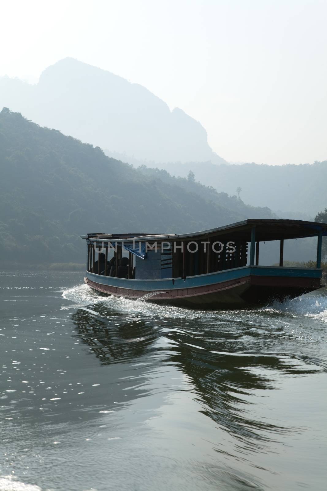 Nam Ou River, boats and landscape with mountains and riverside villages by kgboxford