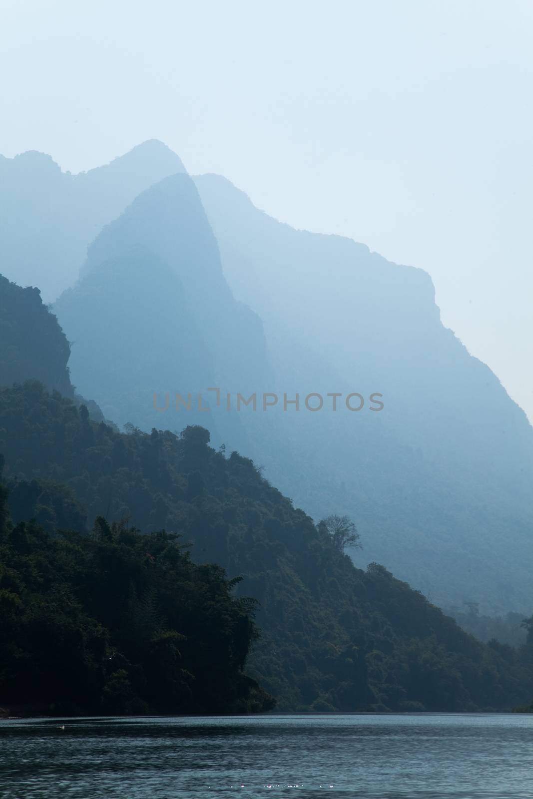 Nam Ou River, boats and landscape with mountains and riverside villages by kgboxford