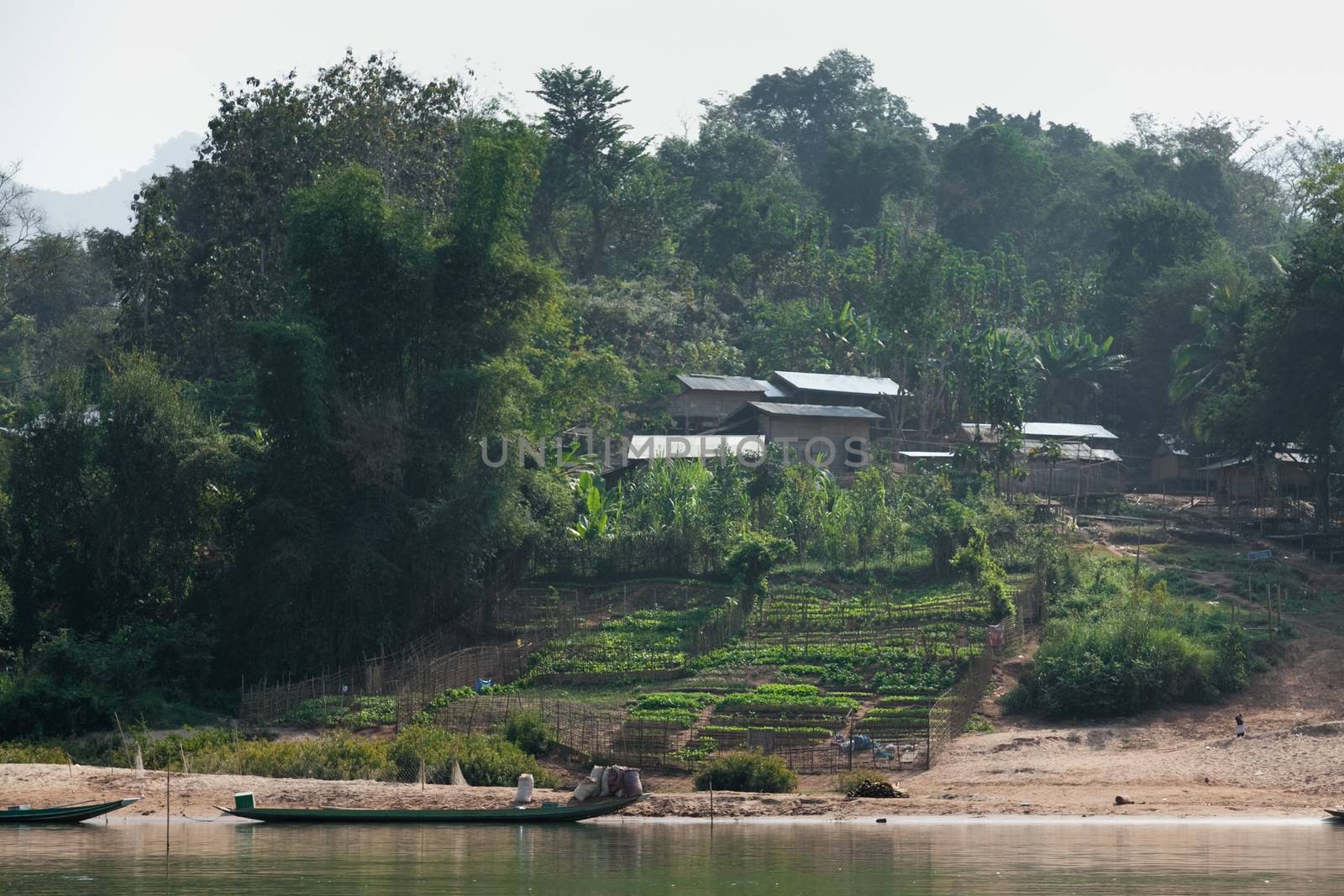 Nam Ou River, boats and landscape with mountains and riverside villages by kgboxford