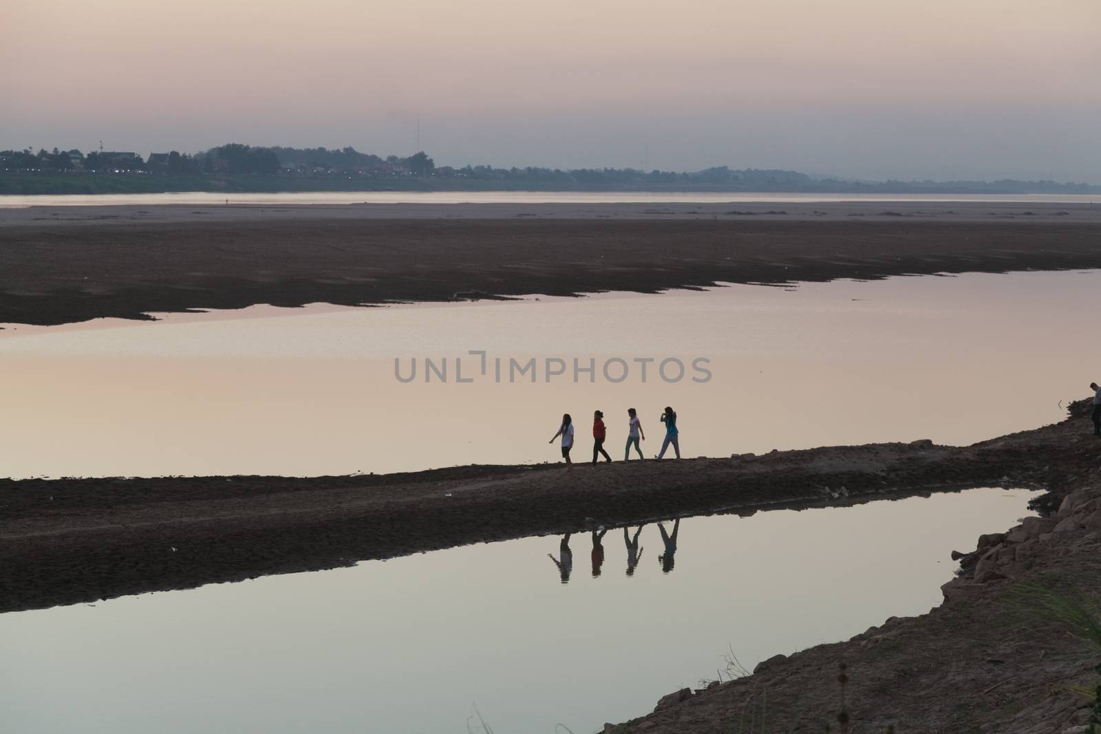 Mekong River, Vientiane, Laos at sunset, with silhouettes reflecting in water by kgboxford