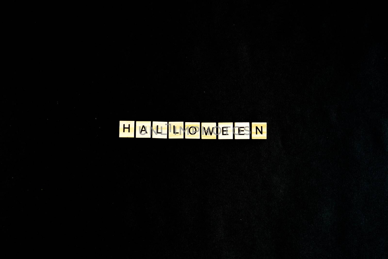Words Halloween. Wooden blocks with lettering on black background decorated with pumpkins. Top view, flat lay. Happy Halloween by Pirlik