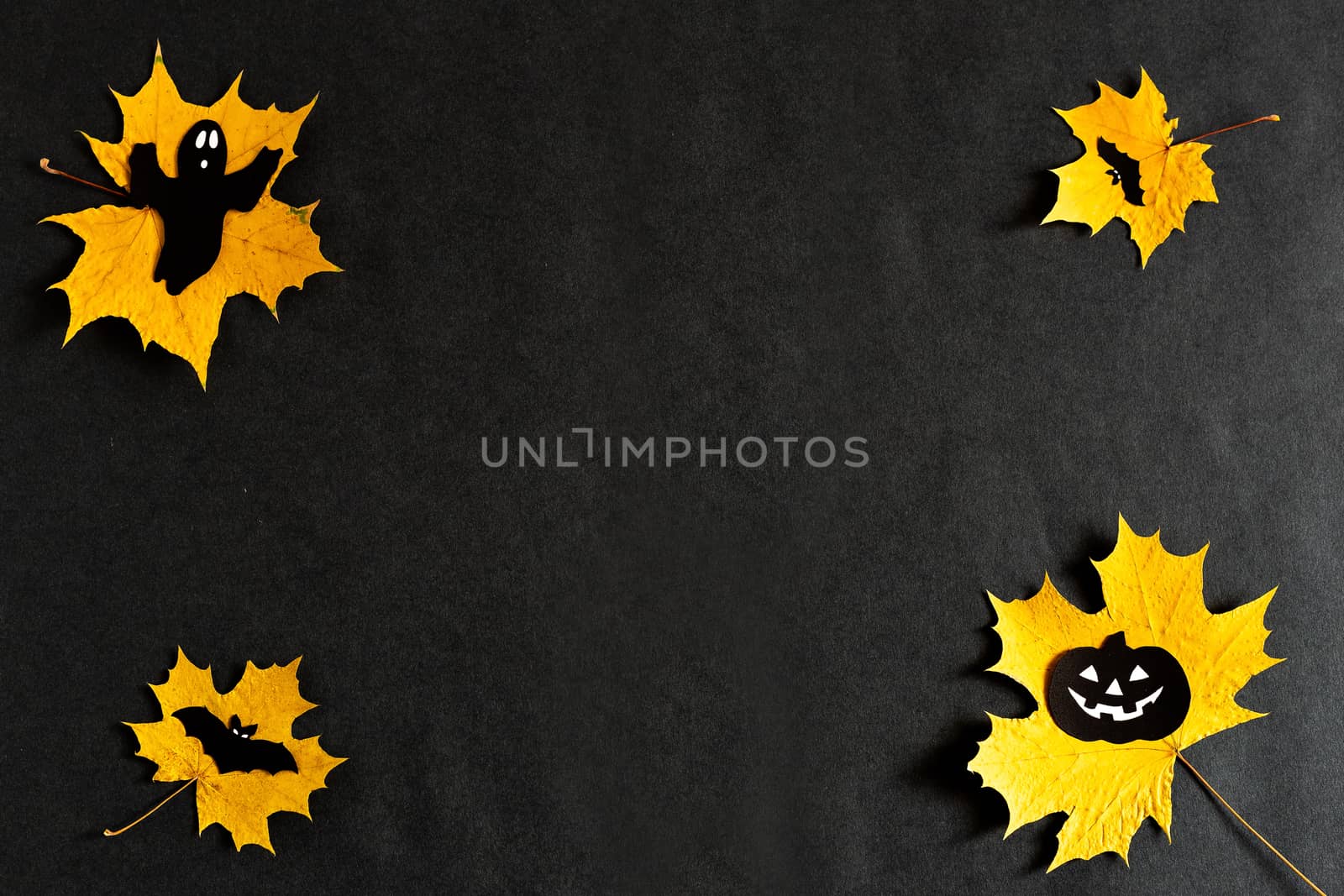 Pumpkin with eyes, Ghost, bats silhouettes made of black paper on yellow maple leaves on a black background. Dark background. Thanksgiving, the concept of Halloween. copyspace, Flatlay for your design by Pirlik