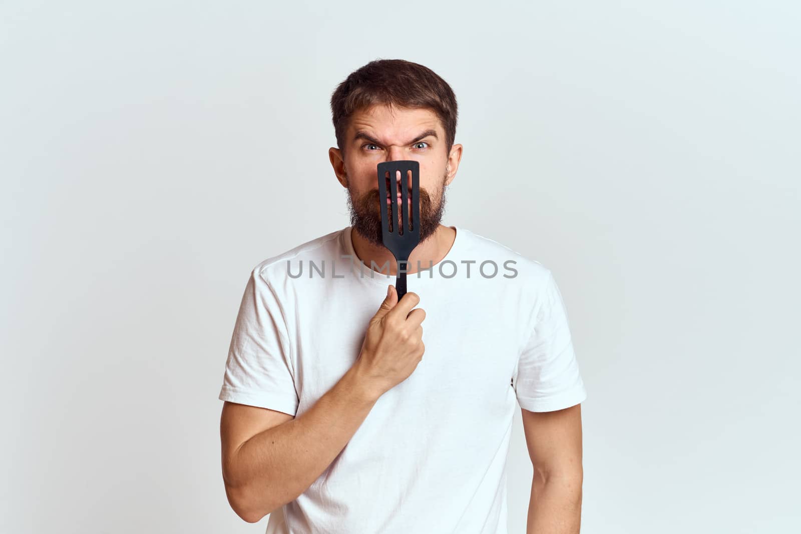 man with cooking shovel and white t-shirt close-up cropped view emotion gesturing with hand by SHOTPRIME