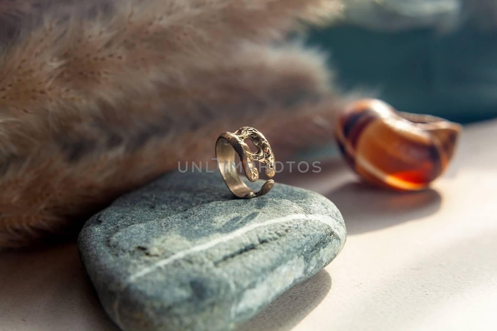 trendy vintage cast brass ring. jewelry womens ring abstract drawing closeup on a gray natural stone with shaddows