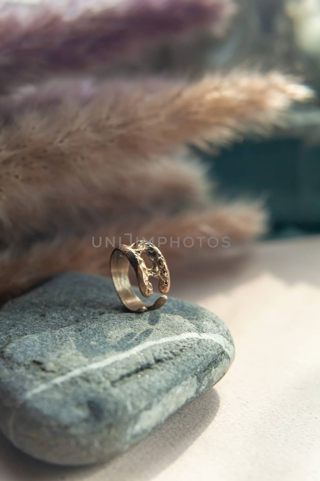 trendy vintage cast brass ring. jewelry womens ring abstract drawing closeup on a gray natural stone with shaddows