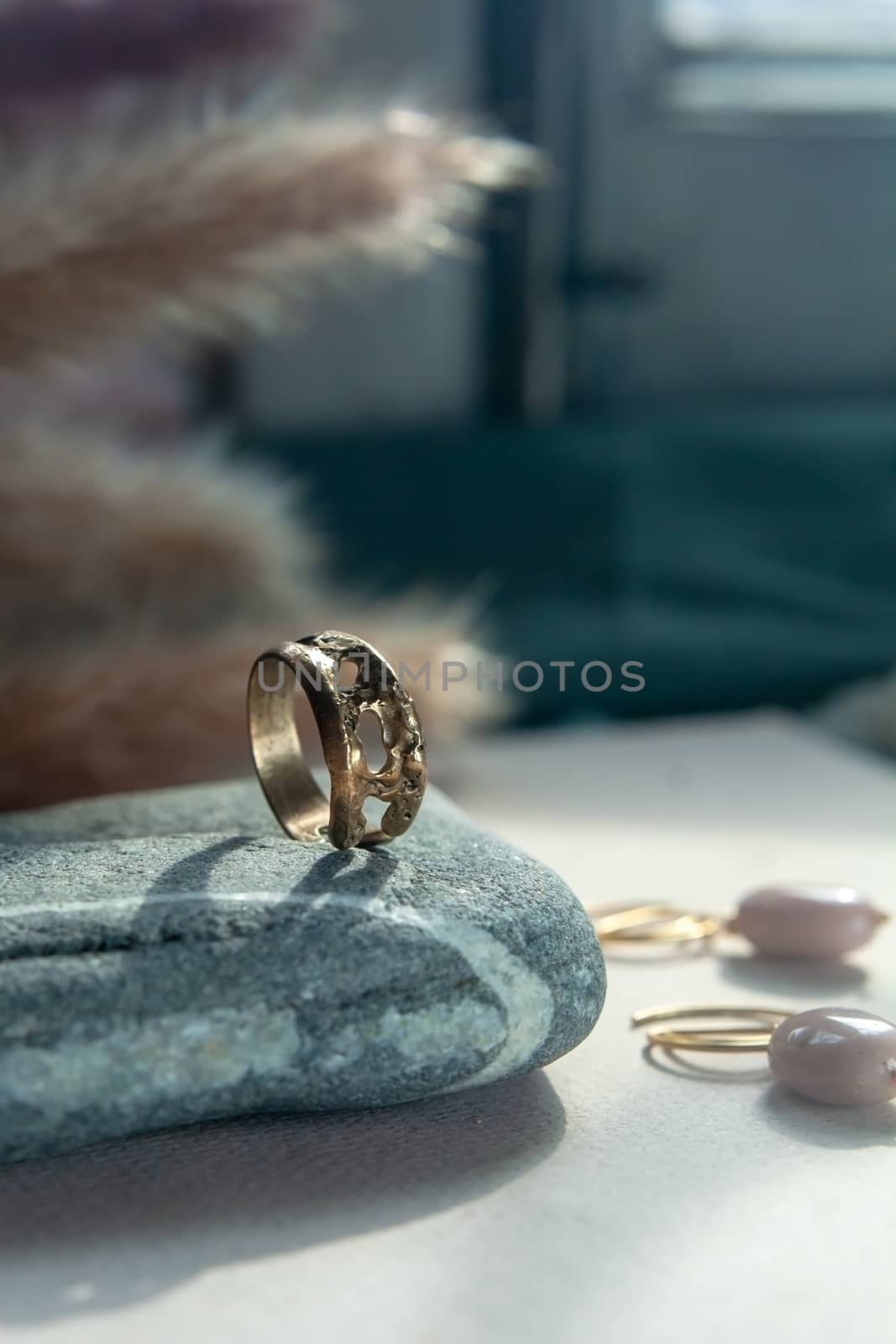trendy vintage cast brass ring. jewelry womens ring abstract drawing closeup on a gray natural stone with shaddows