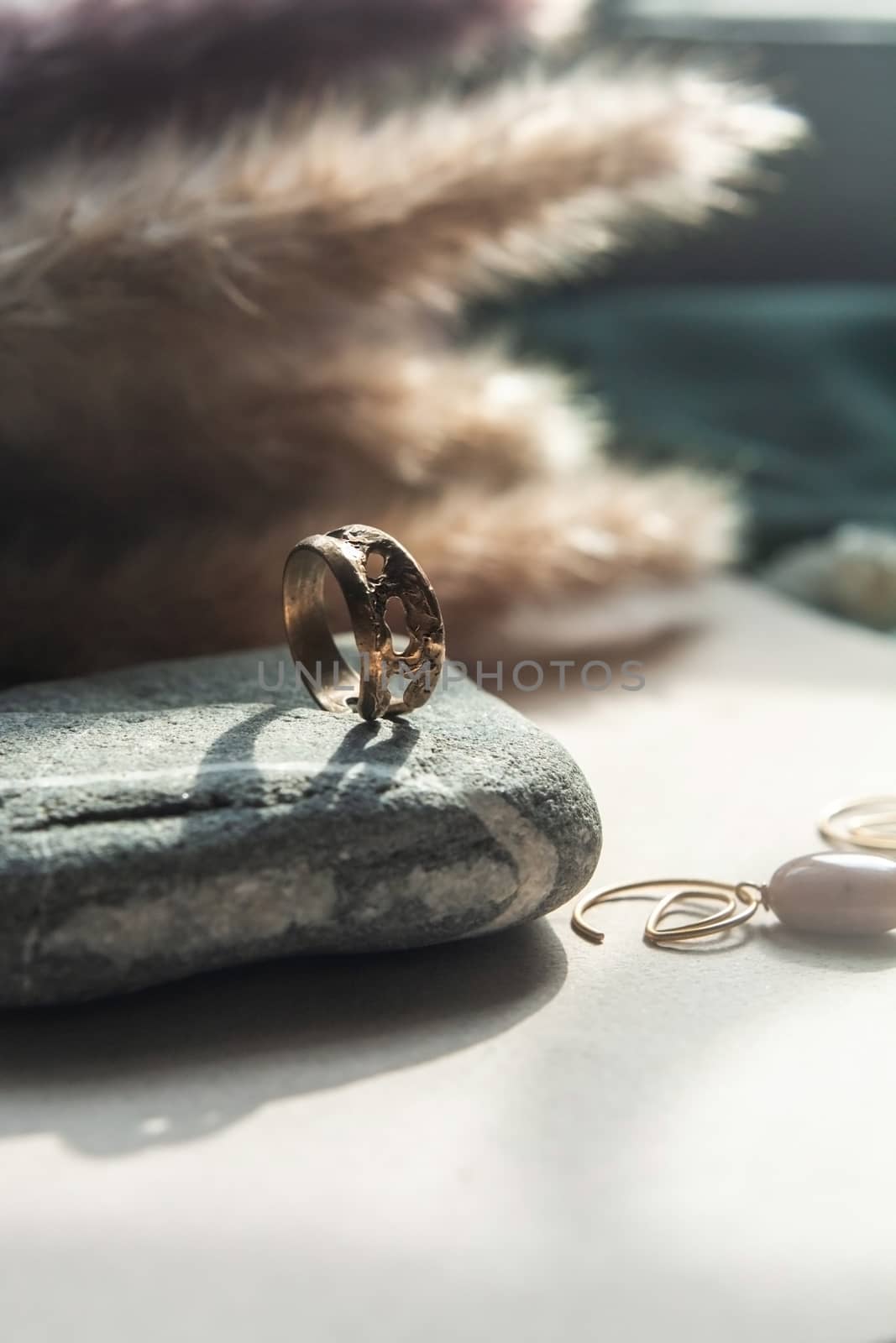 trendy vintage cast brass ring. jewelry womens ring abstract drawing closeup on a gray natural stone with shaddows