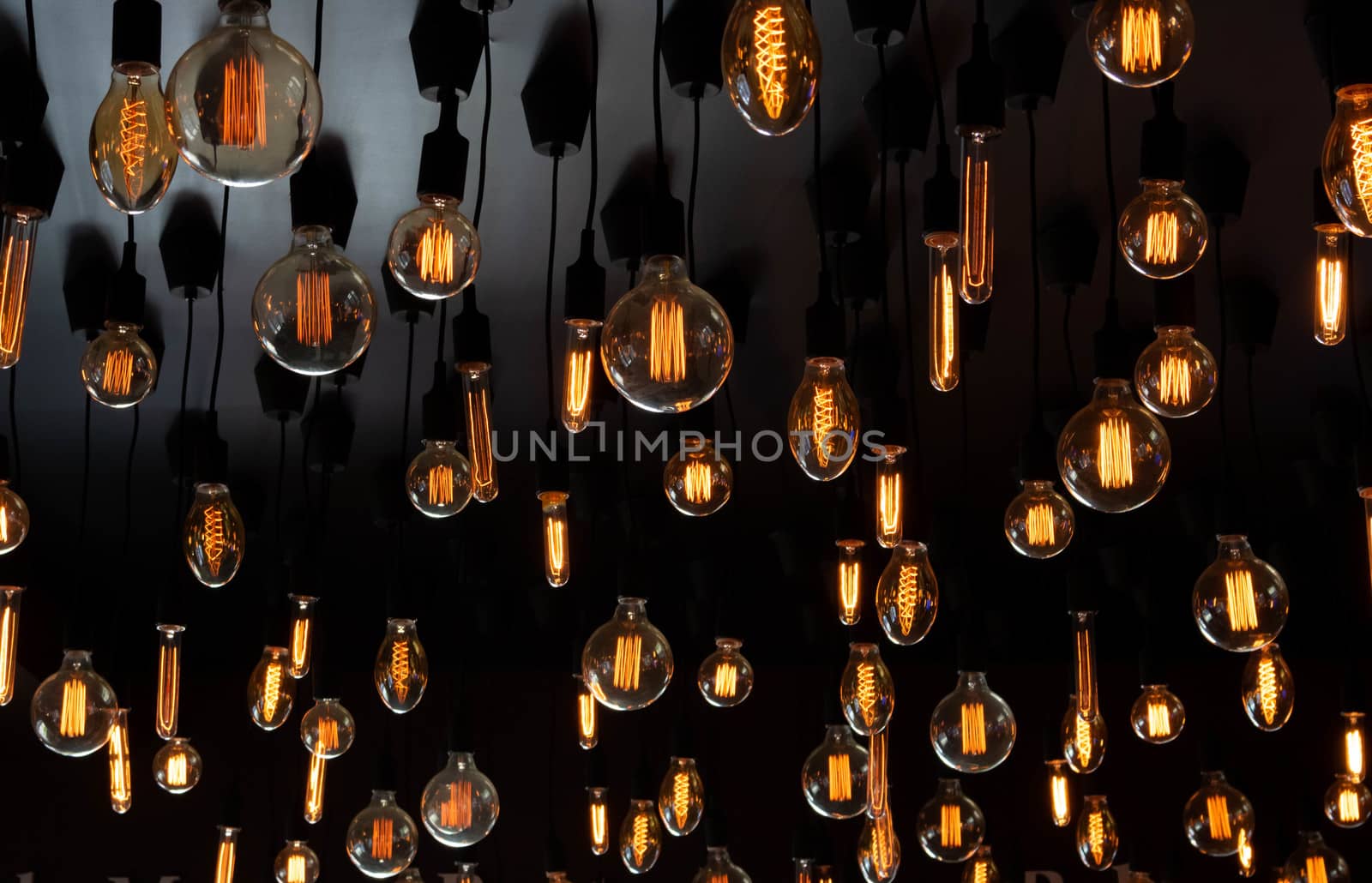 Retro Edison lamp on a black background of the ceiling. Concept idea.