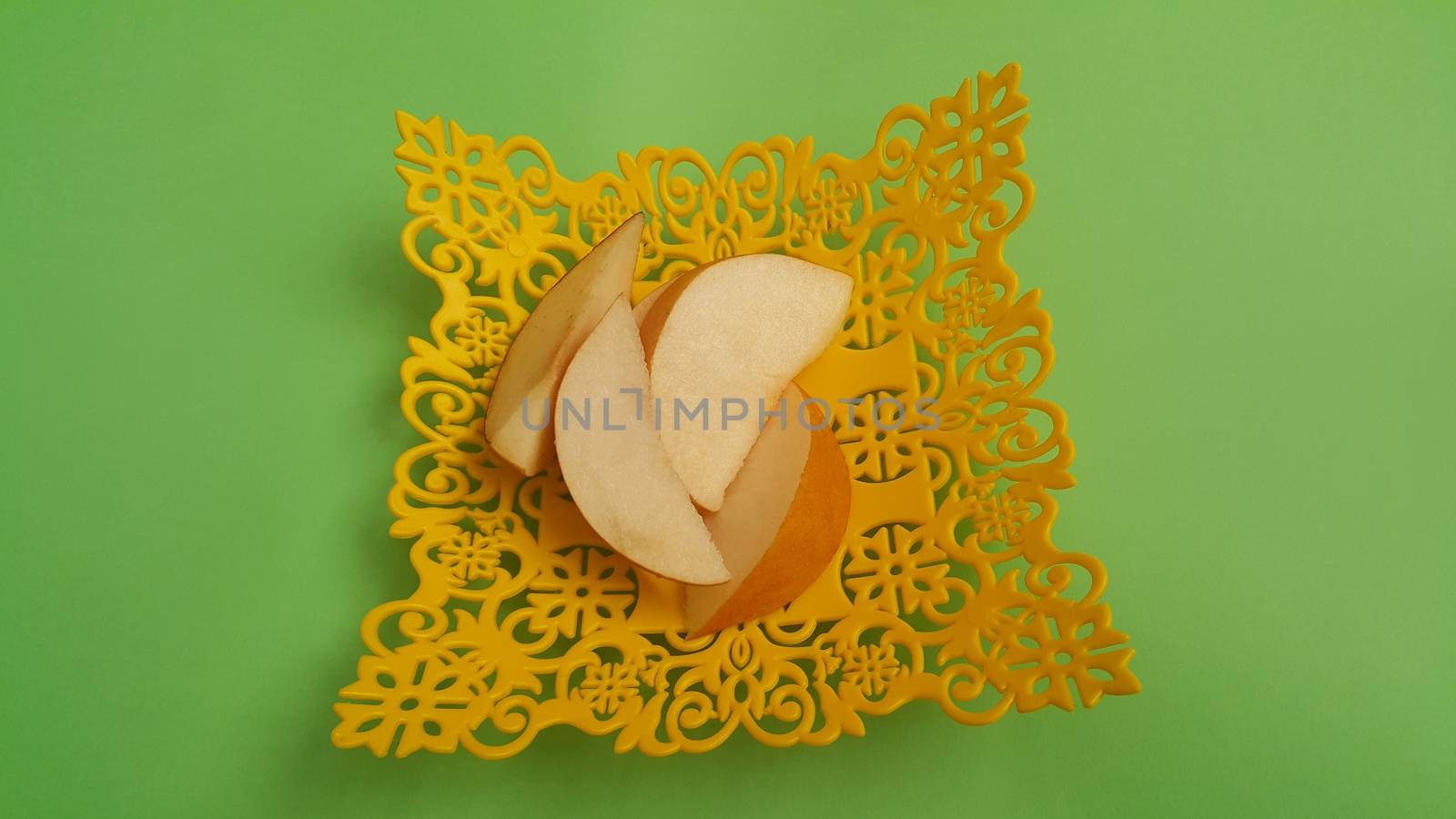 Close up view of apple slices placed in plastic yellow changair or container on a wooden floor. Fruit background for text
