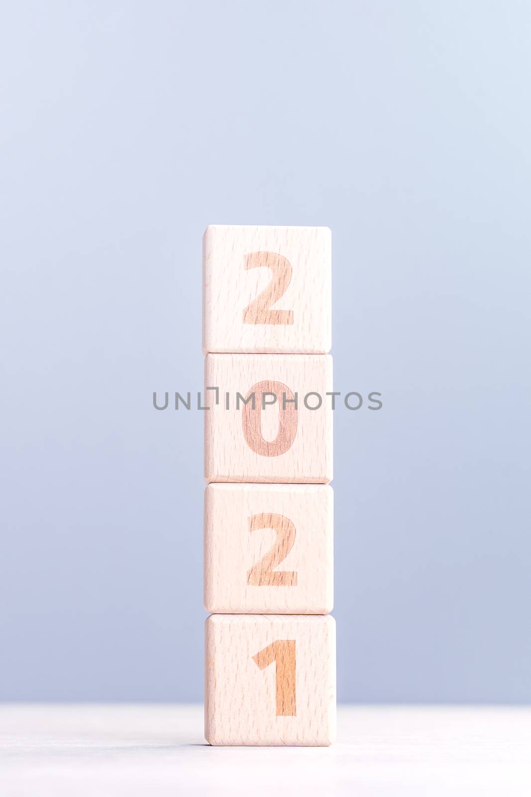 2021 New Year abstract design concept - Number wood block cubes isolated on wooden table and light mist blue background.