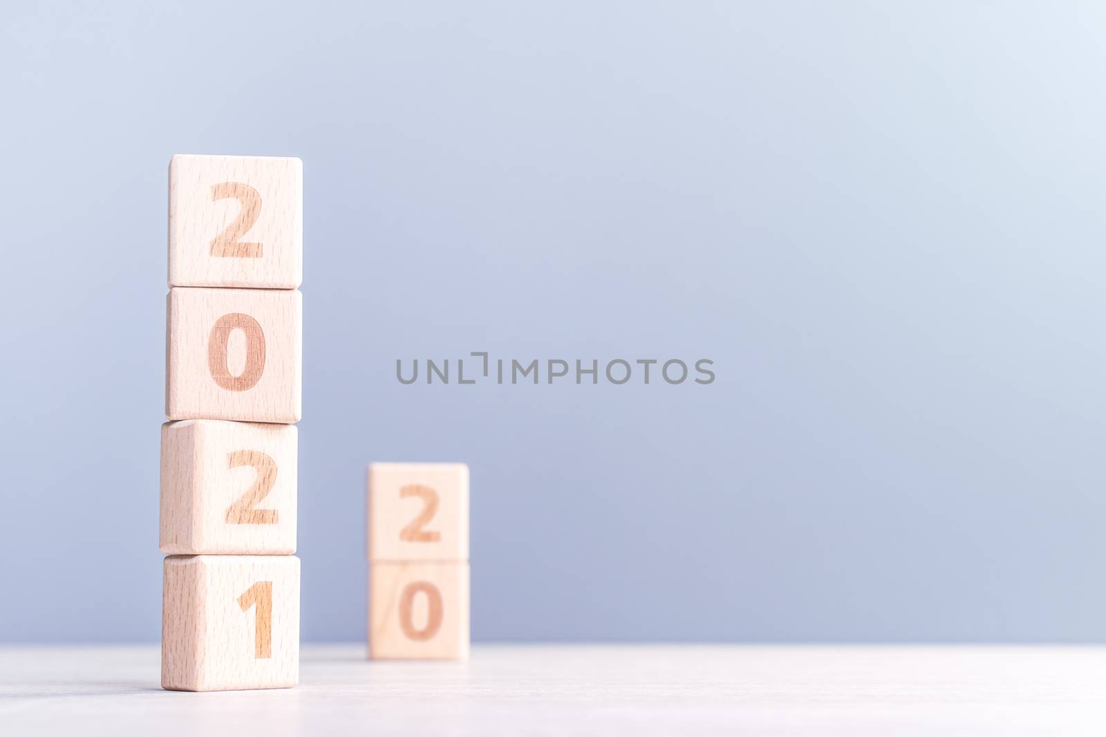 2021 New Year abstract design concept - Number wood block cubes isolated on wooden table and light mist blue background.