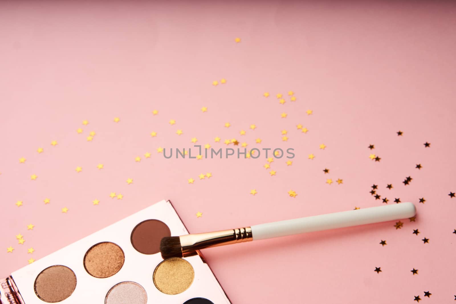 makeup brushes and eyeshadow professional cosmetics on pink background by SHOTPRIME