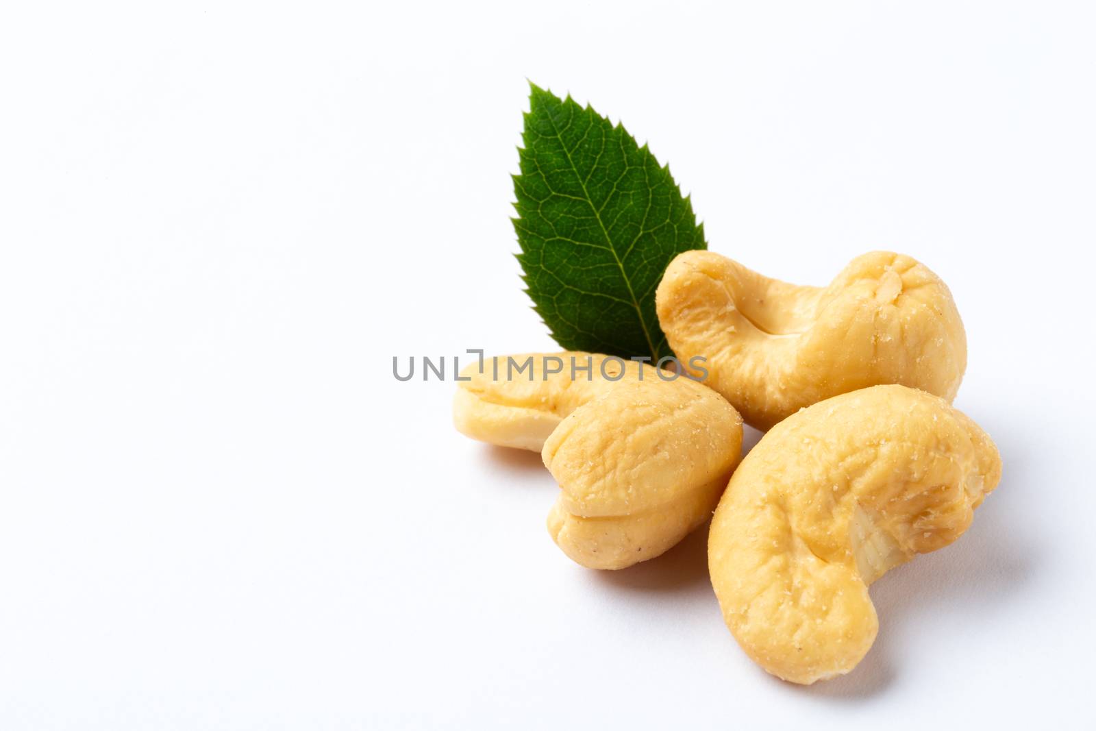 Cashew nuts with a green leaf on white background by 25ehaag6