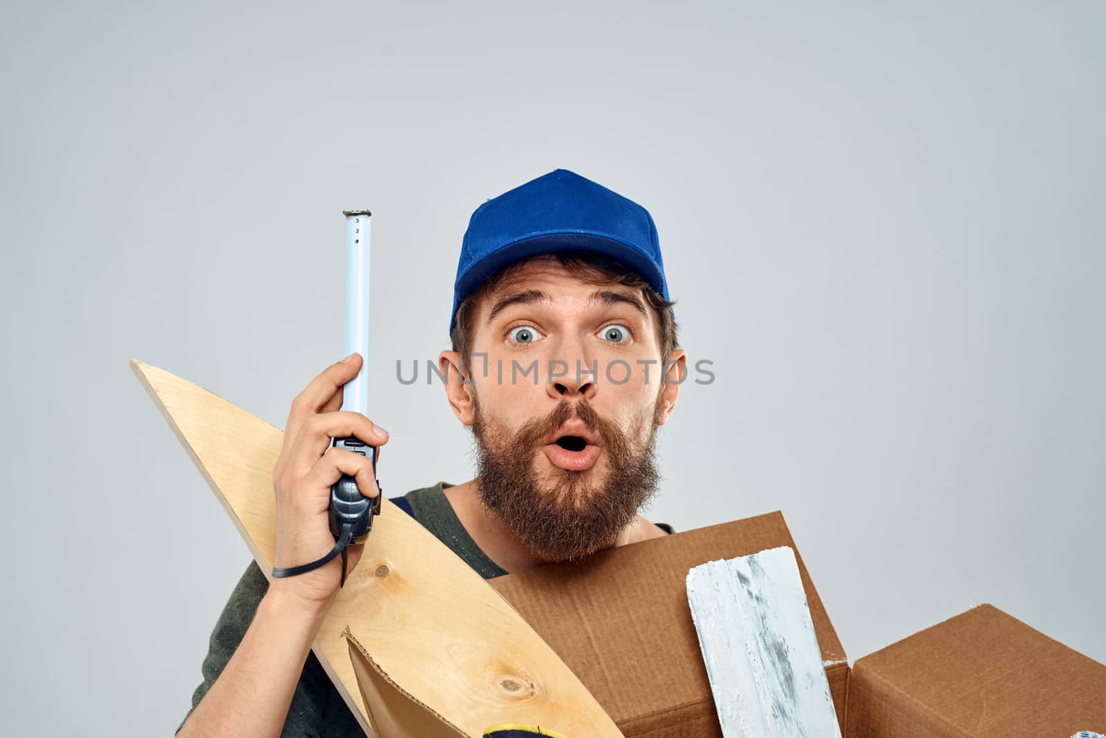 man in work uniform with box in hands tools lifestyle light background. High quality photo