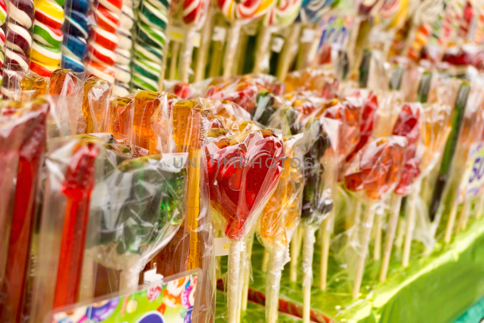 Counter with multicolored sweet lollipops of different shapes