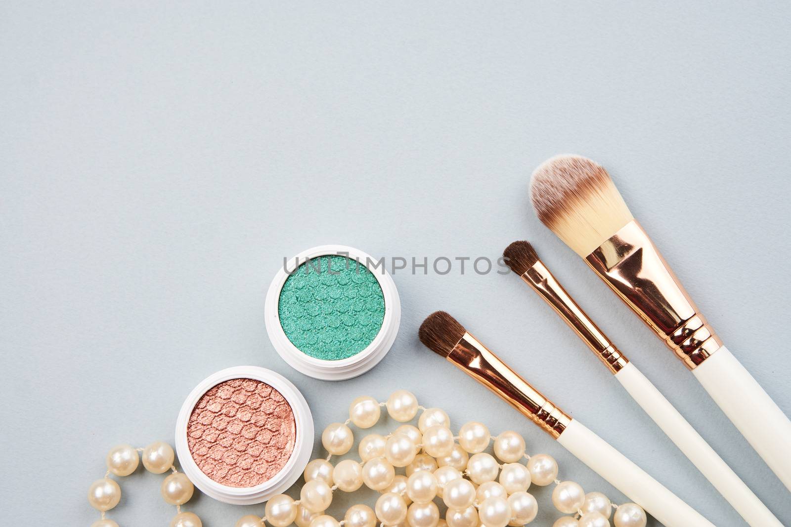 eyeshadow accessories makeup brushes merchandise collection professional cosmetics on gray background by SHOTPRIME