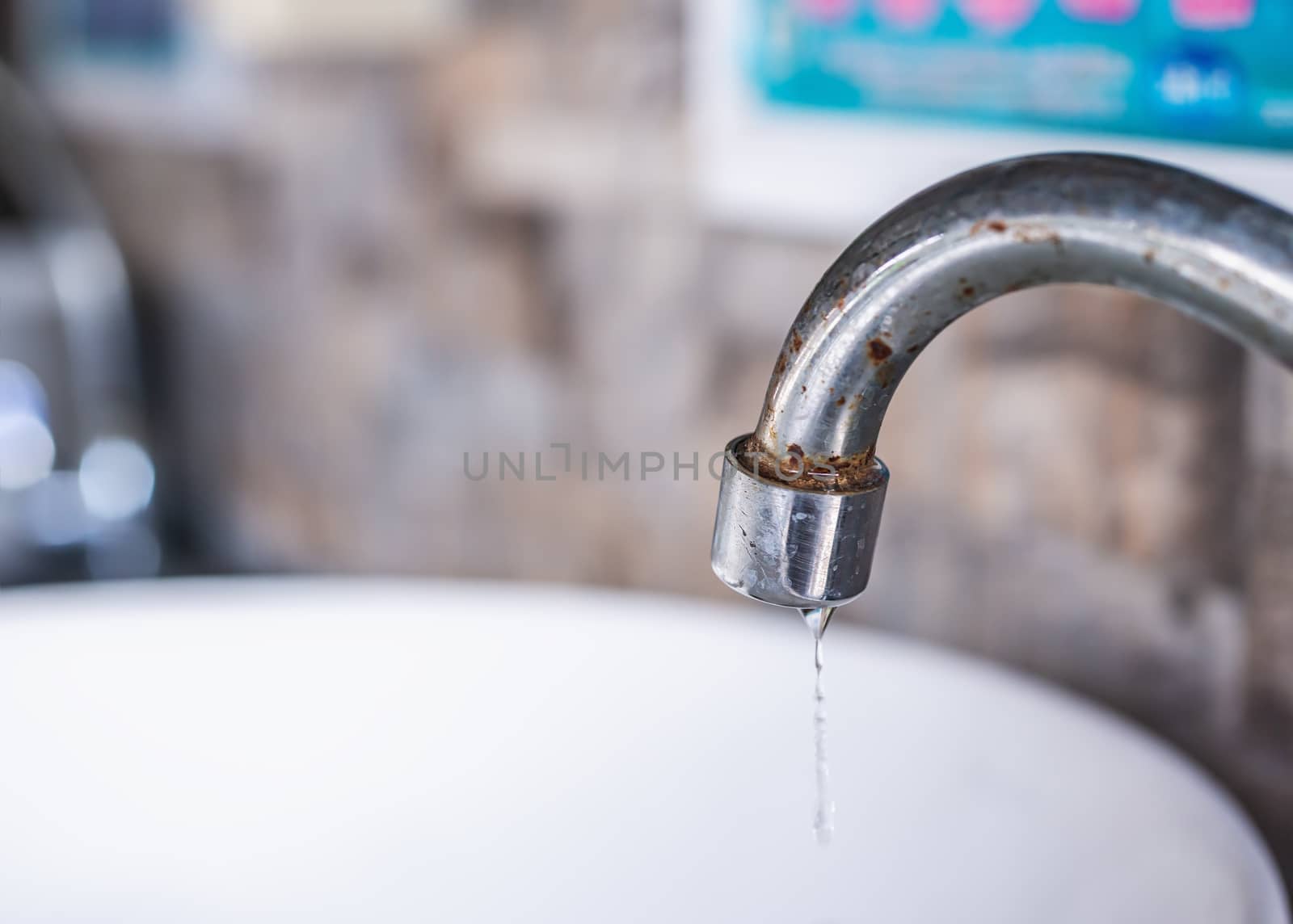 Water drop from old water tap blurred background, Save water cocept, Save world and save life concept