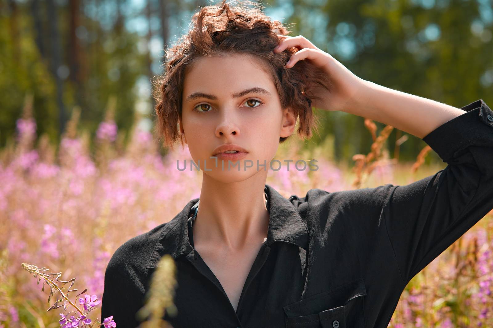 Beautiful young girl holding a bouquet of lupines in her hand. Soft focus