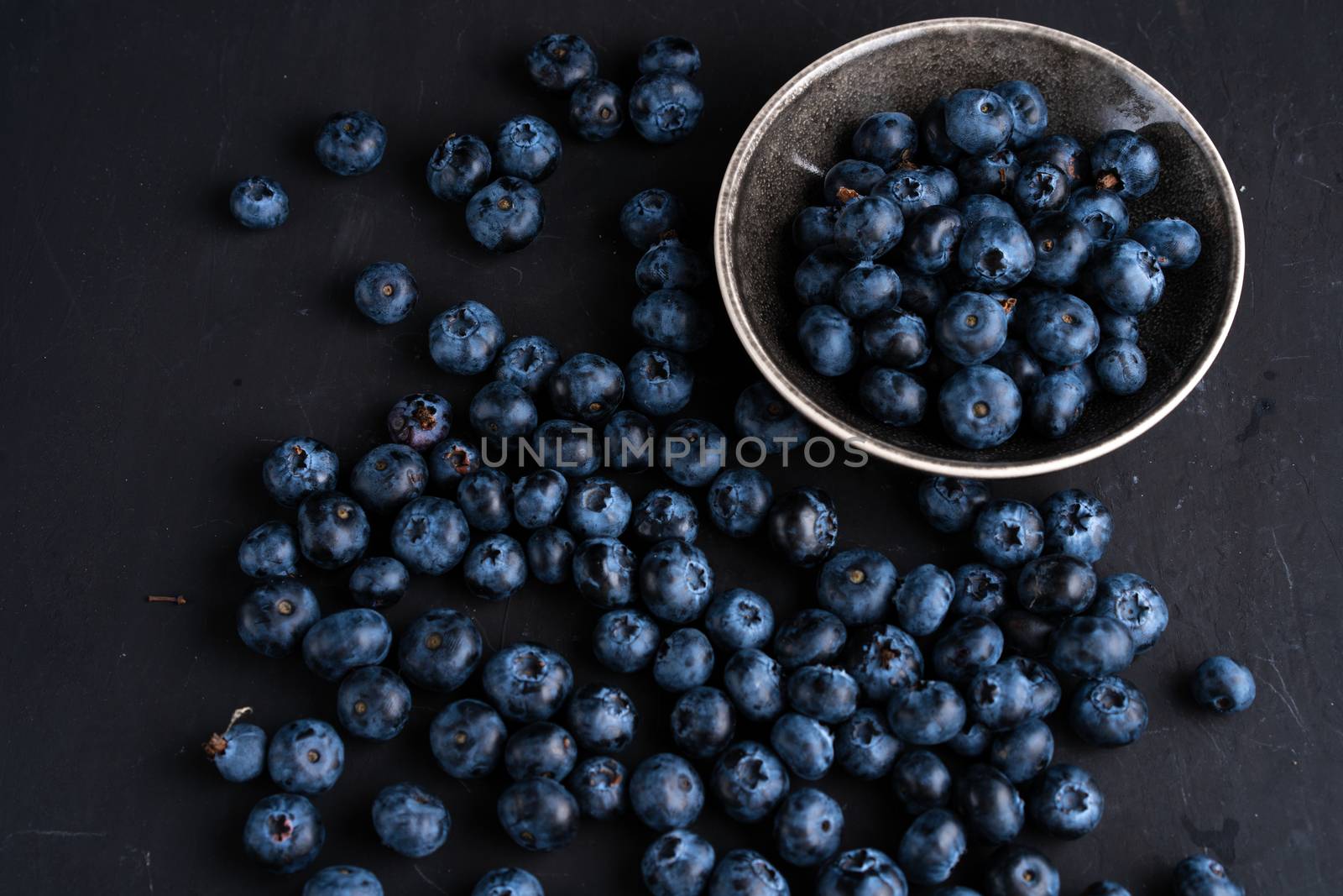 Blueberry antioxidant organic superfood in ceramic bowl concept for healthy eating and dieting nutrition Top view on dark black background