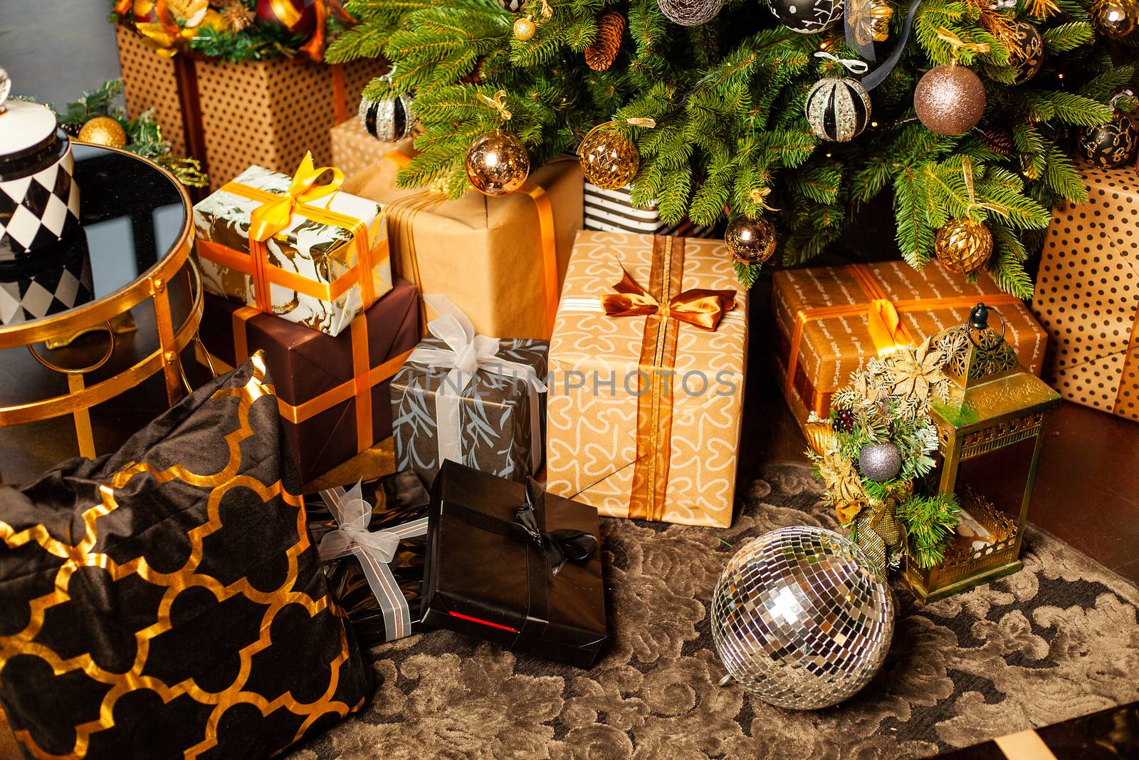 Christmas tree decorated with gold balls. Under the Christmas tree a large number of Christmas gifts. Christmas holiday concept. A huge number of gift boxes under Holiday background