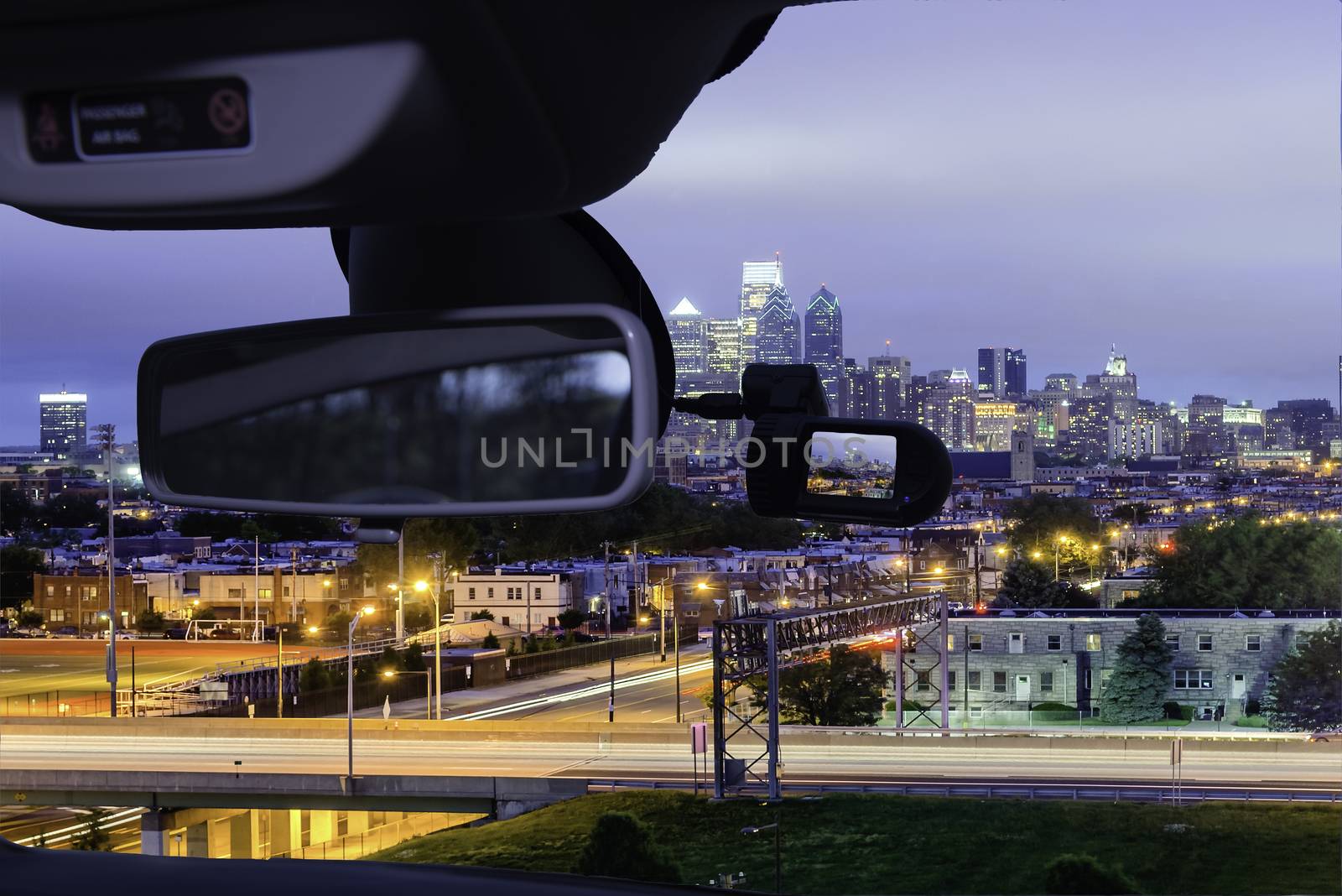 Looking through a dashcam car camera installed on a windshield with view of Philadelphia skyline at night as seen from the Stadium District, USA