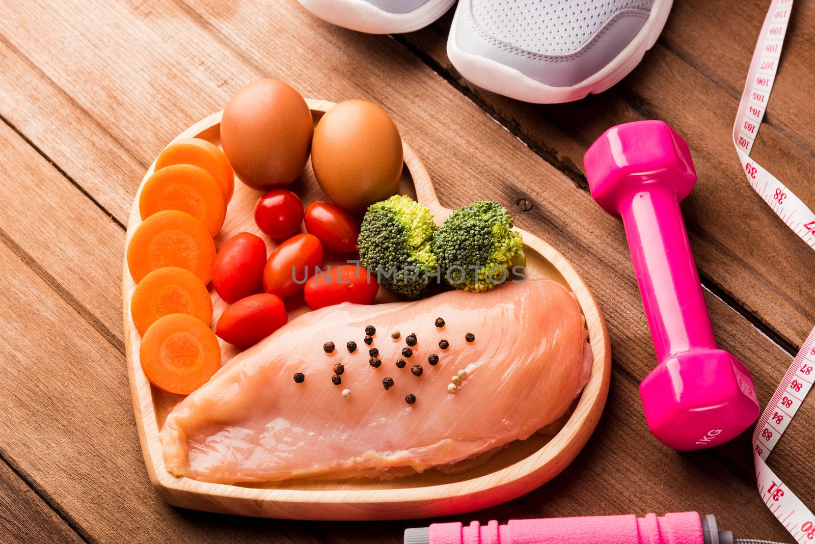 Top view of Raw chicken breasts fillets no boneless with spices in heart plate wood and sport or athlete's equipment dumbbell
running shoes on wooden background, Healthy lifestyle diet food concept