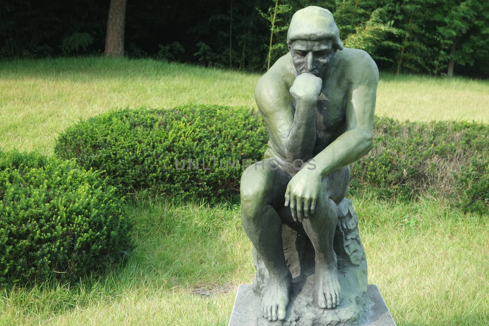 CHUNCHEON, SOUTH KOREA- JANUARY-10, 2019: Green statue of thinker Auguste Rodin, setting naked on a rock in a public park