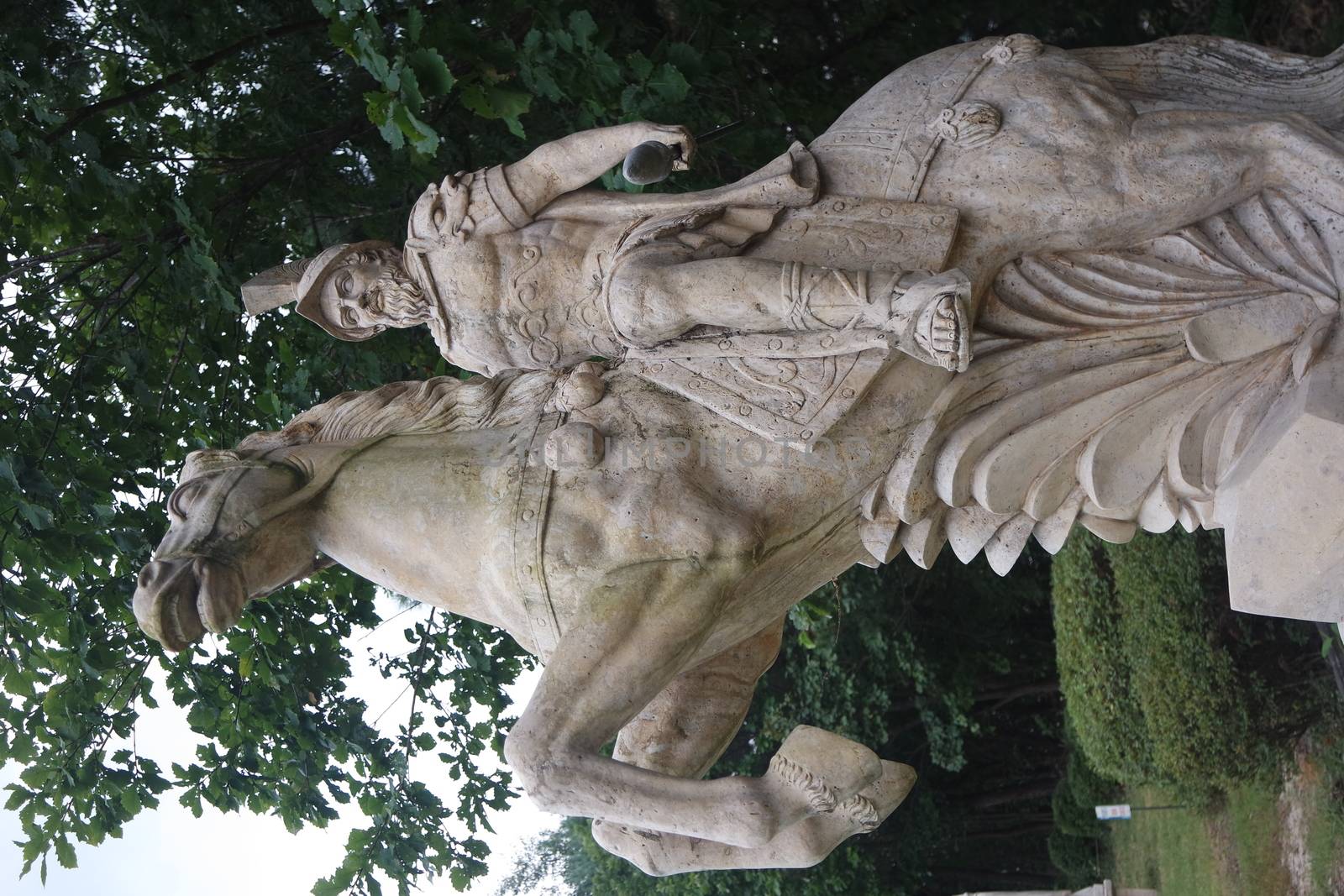 Statue made of white stone marble of an ancient famous soldier riding on the horse- White marble statue of an ancient man holding a scroll and riding a horse