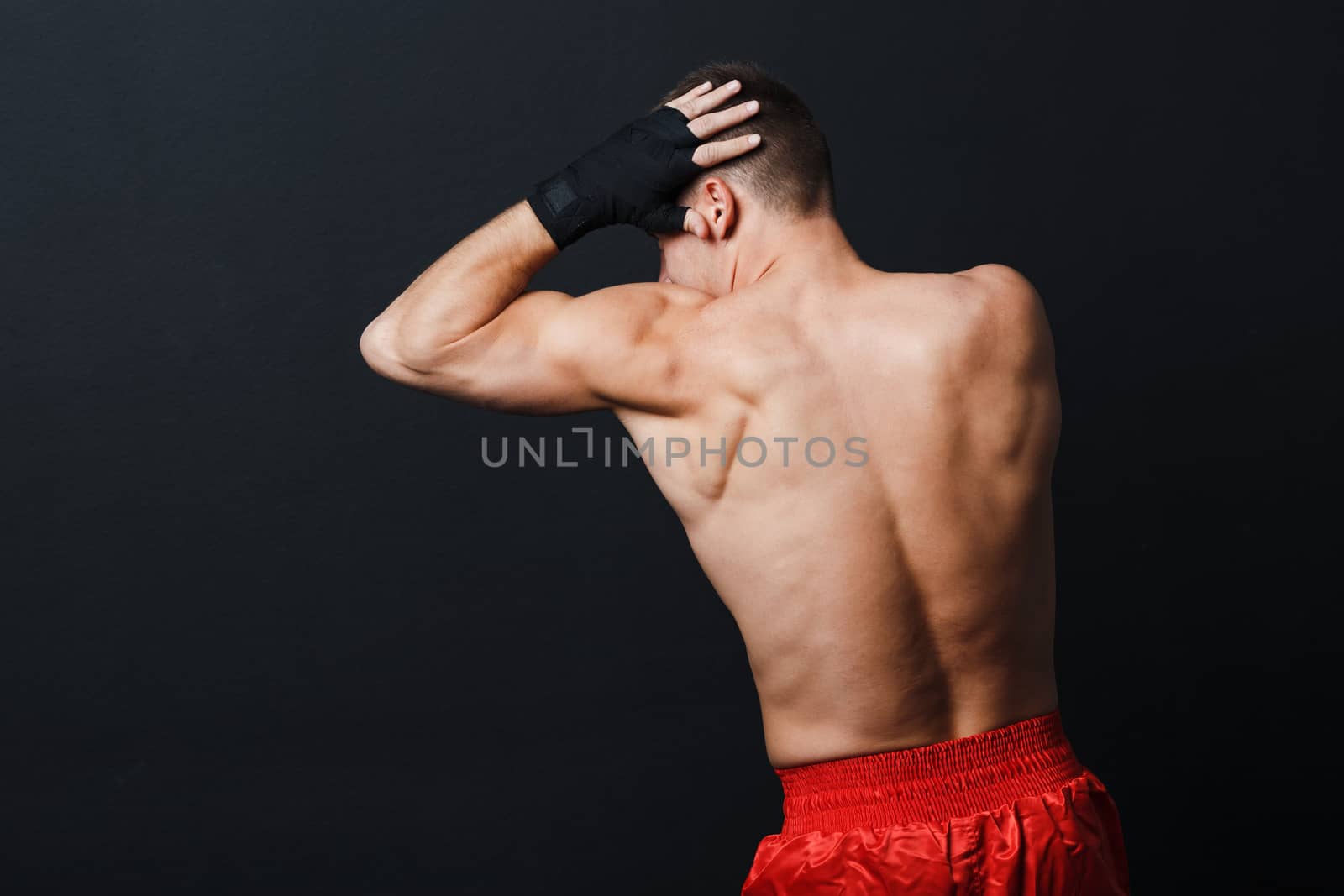 Sportsman muay thai man boxer stance ad elbow punch at black background.