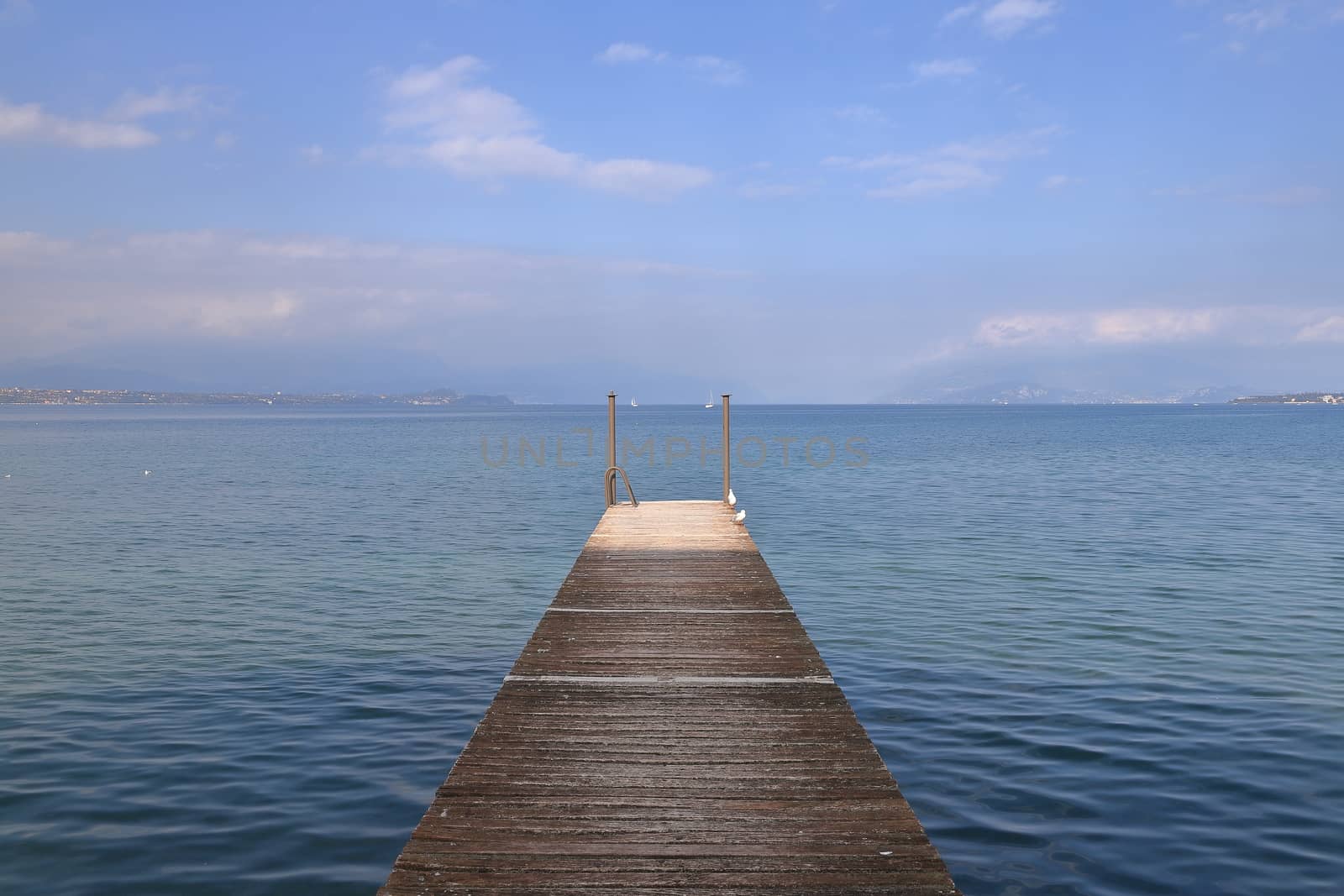 The view along a wooden pier on the banks of Lake Garda in North East Italy.