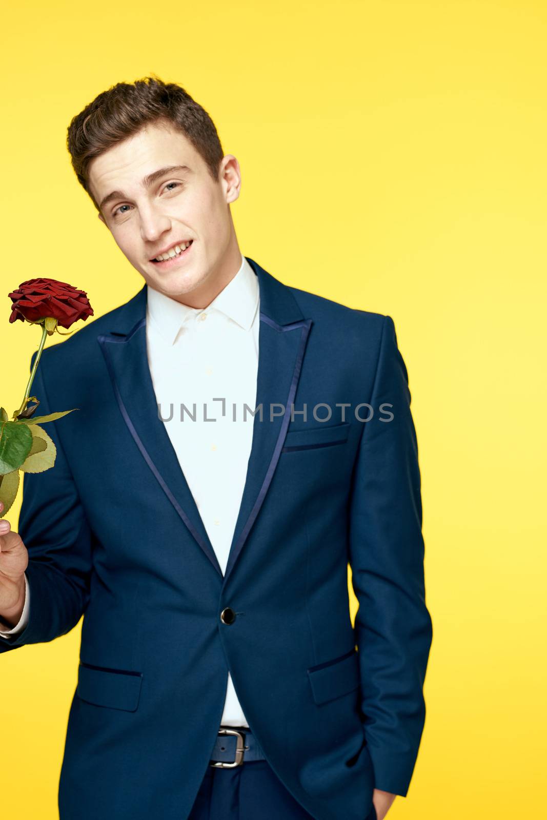 Gentleman in classic suit on yellow background with red rose romance cropped view. High quality photo