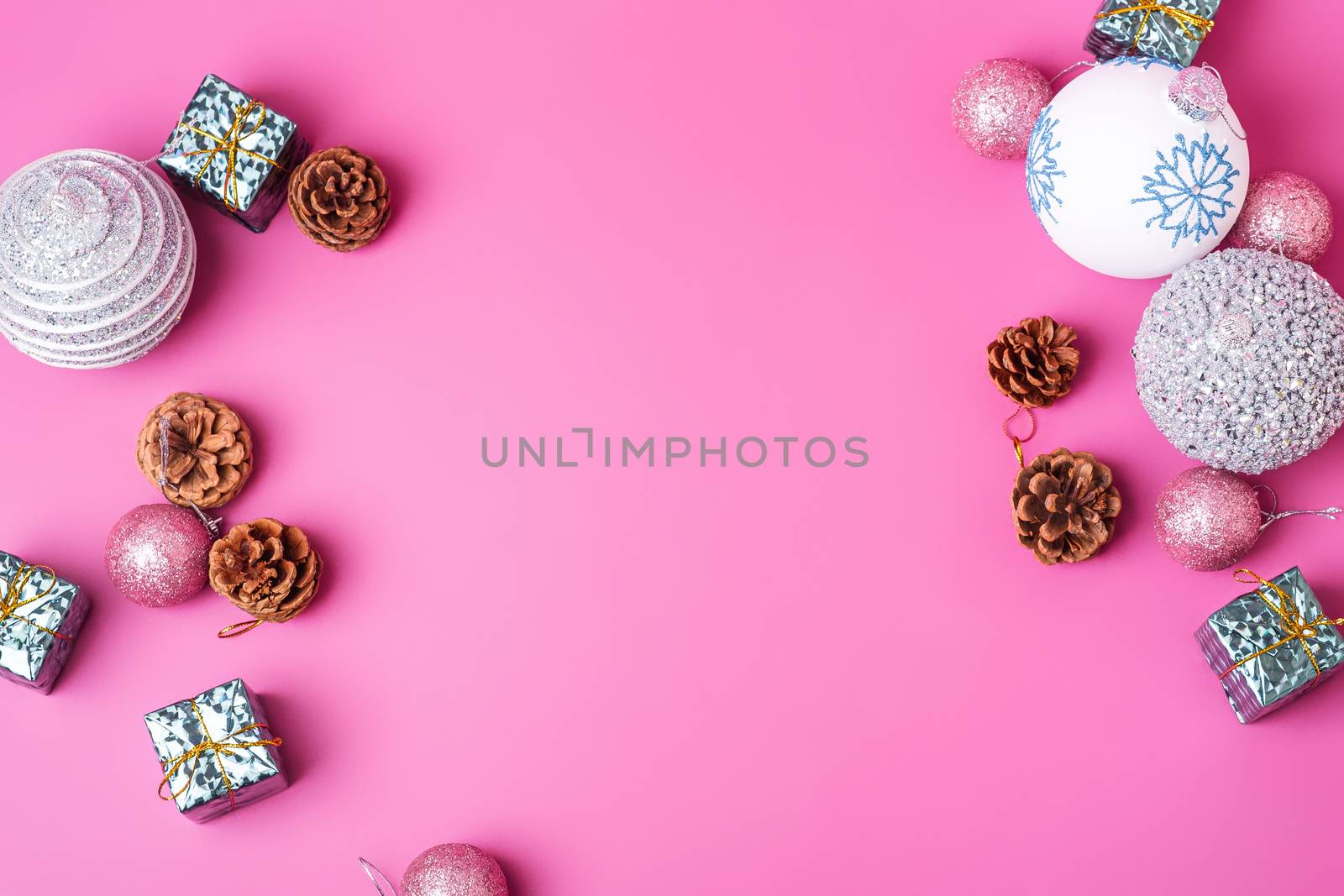 Christmas New Year composition. Gifts, fir tree cones, silver ball decorations on pink background. Winter holidays concept. Flat lay, top view, copy space